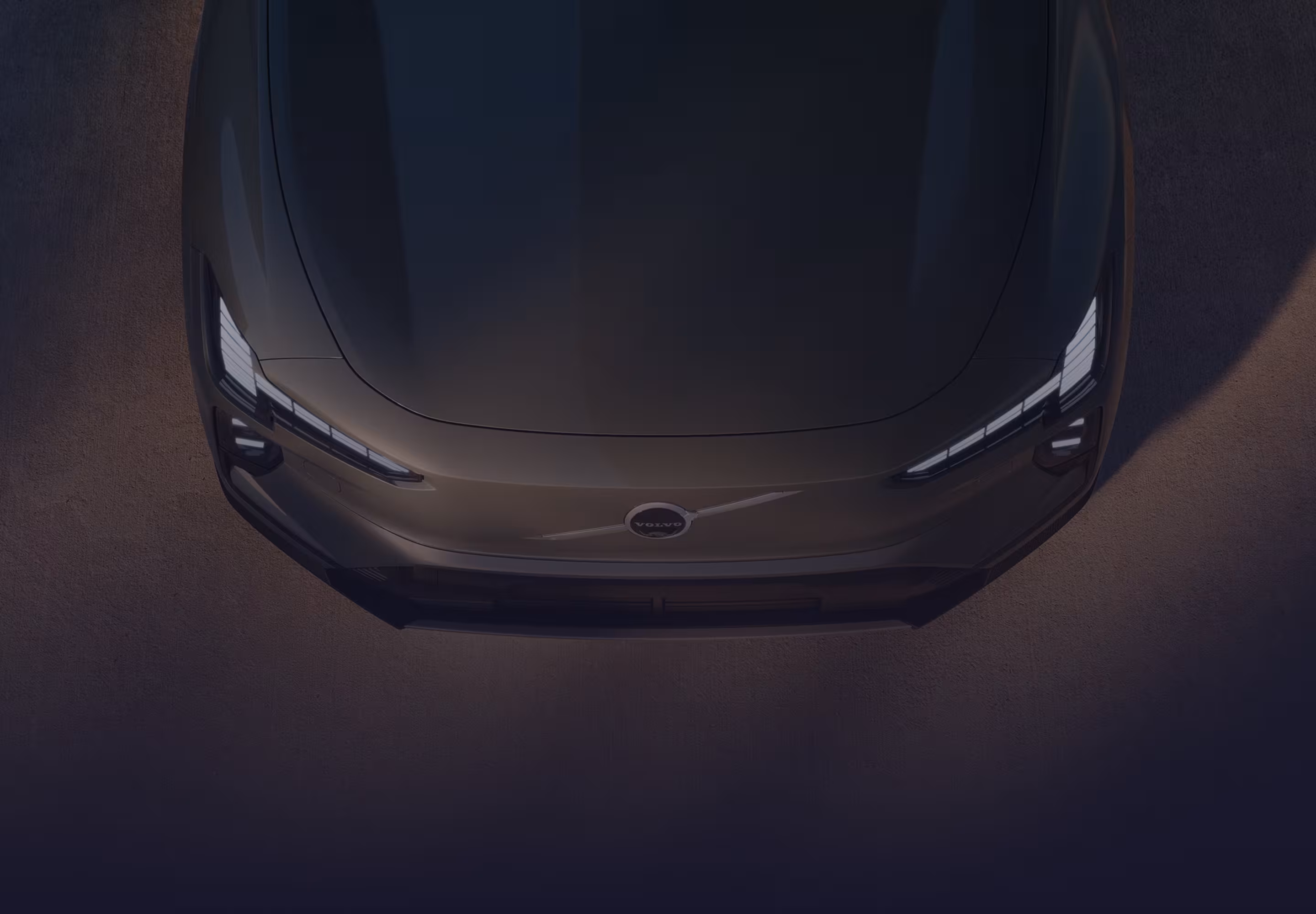Vista aérea del capó y las ópticas delanteras de un Volvo oscuro.
