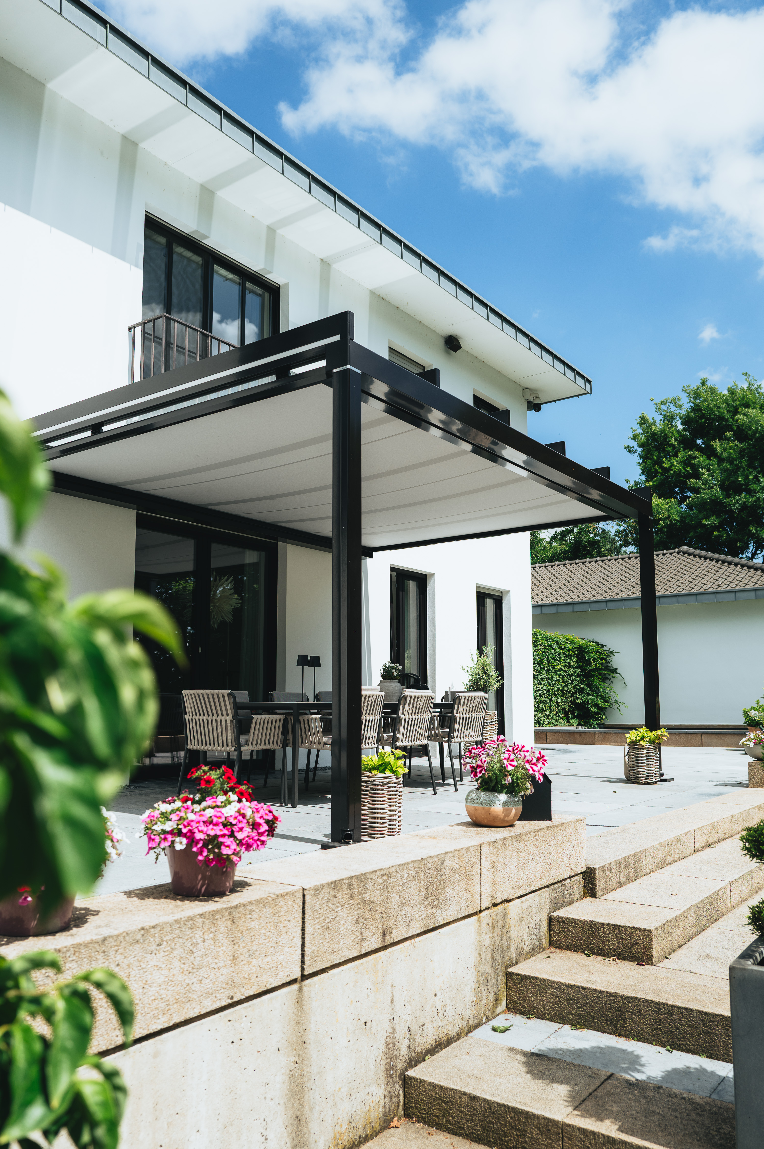 Beleuchtete Terrassenüberdachung mit dunklen Aluminiumprofilen