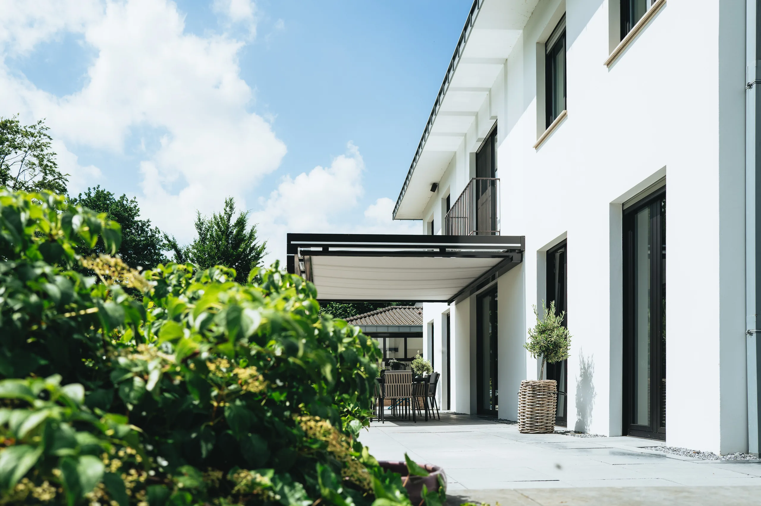 Terrassenüberdachung mit Glas-Schiebeelementen an einem Einfamilienhaus