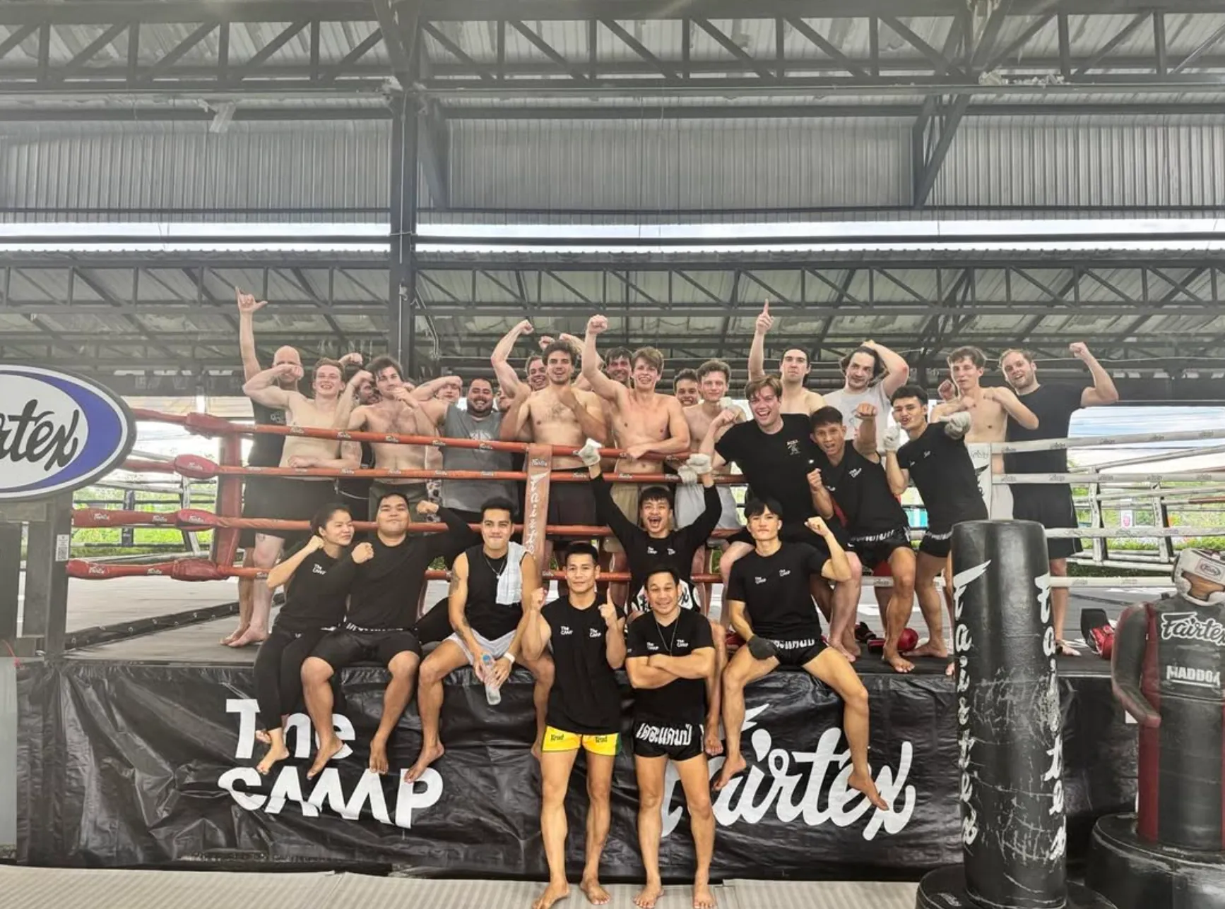 The Camp training community smiling together by the boxing ring