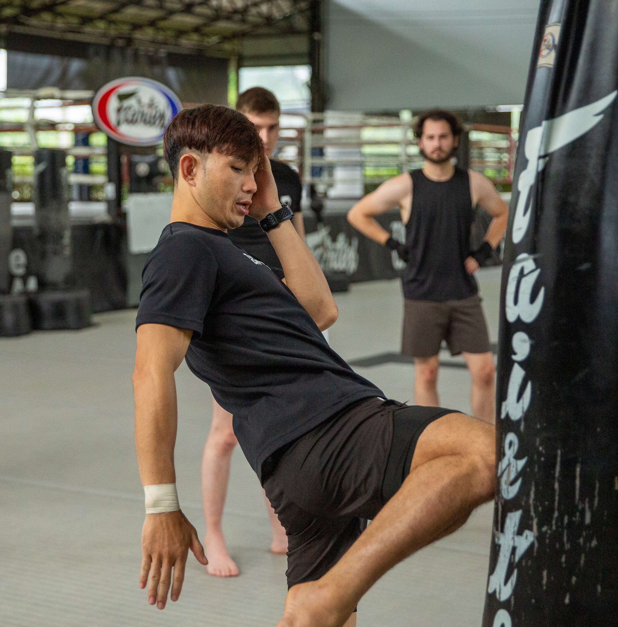 Muay Thai trainer demonstrating technique to guests during Standard Muay Thai Session at The Camp