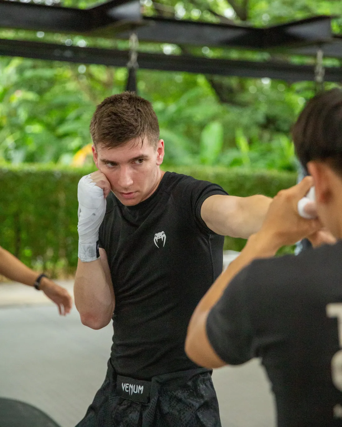A student facing his trainer during pad practice