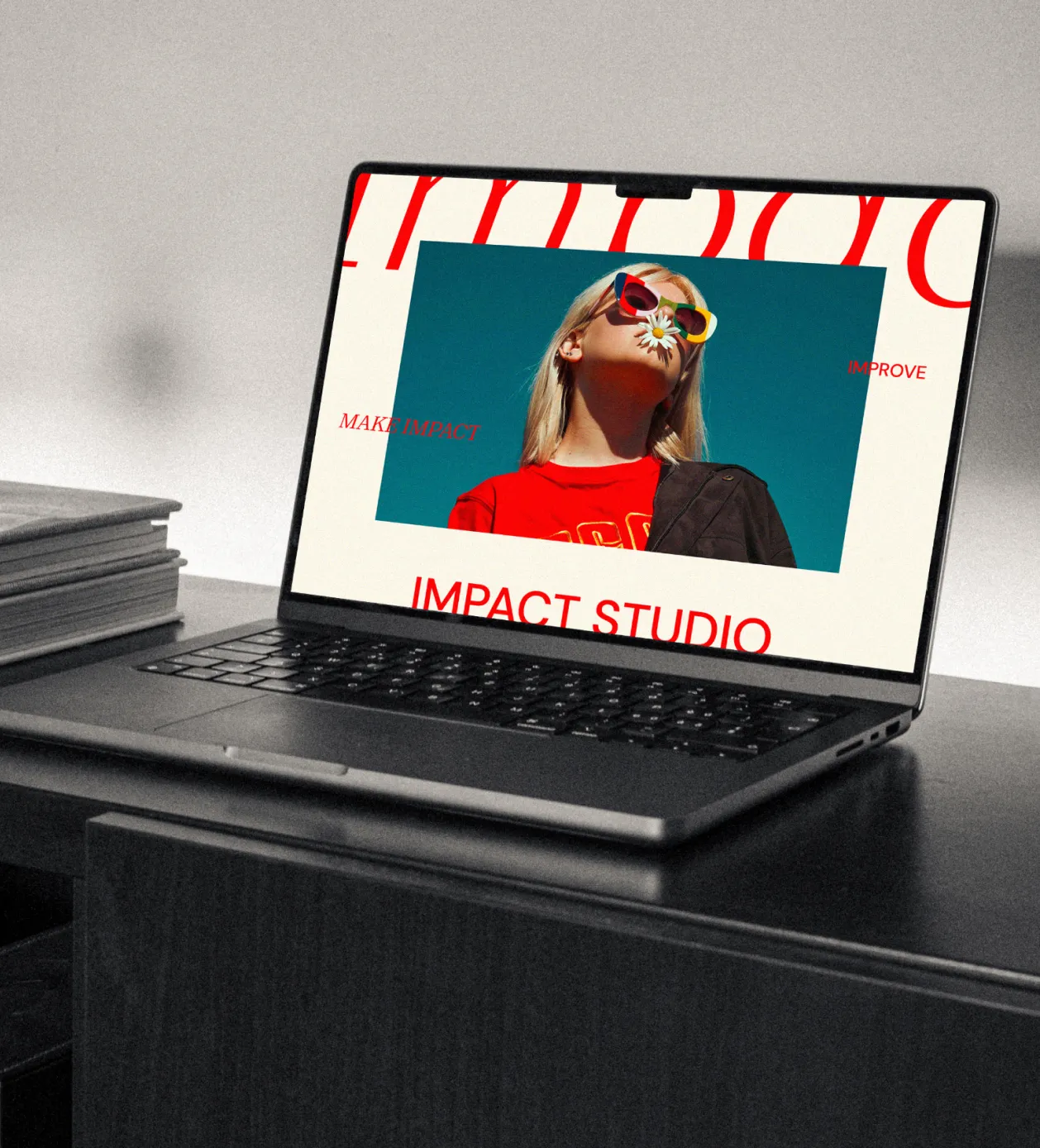 Laptop on a dark desk displaying a website with a photo of a woman wearing colorful sunglasses holding a daisy in her mouth against a blue sky background.