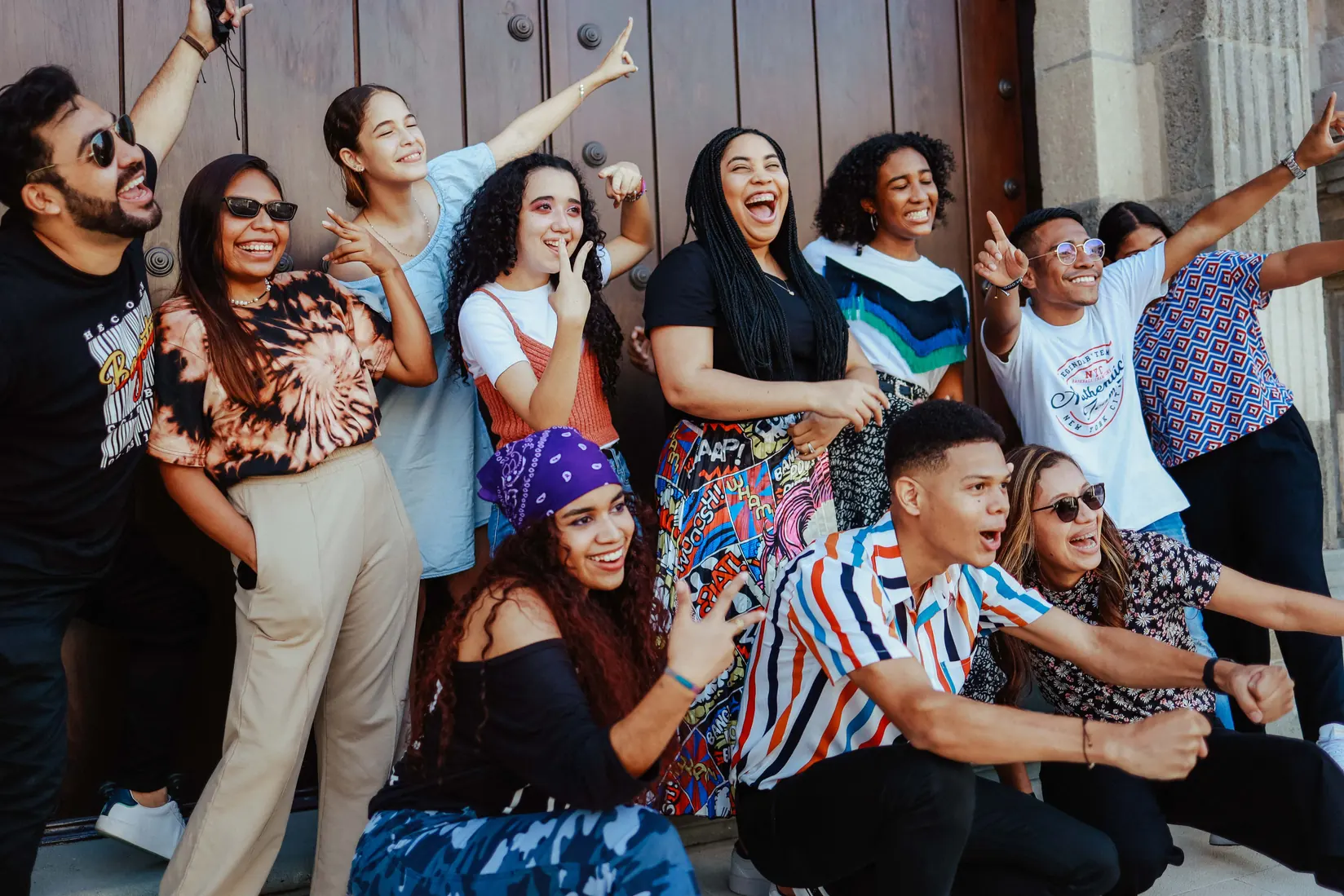 Group of creators celebrating together in front of a wooden door