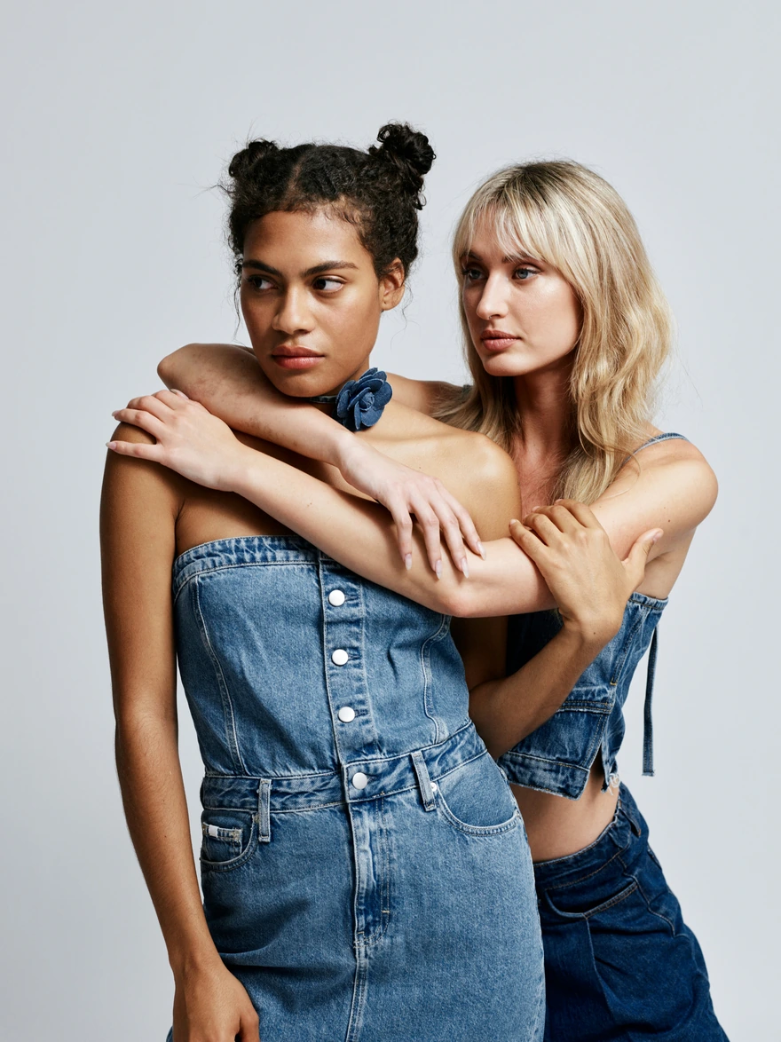 Two creators in denim posing together in a studio