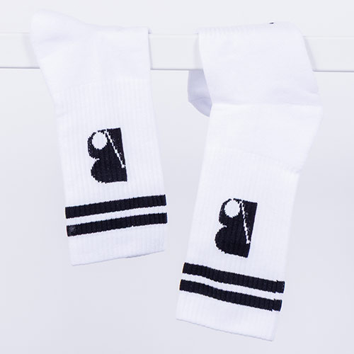 Ein Paar weiße Socken mit schwarzen Streifen und einem schwarzen stilisierten B-Logo, aufgehängt an einer Stange vor hellem Hintergrund.