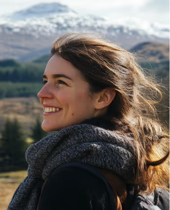Jamie smiling outdoors with mountains behind her