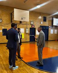 Adults having a discussion on a school gymnasium basketball court