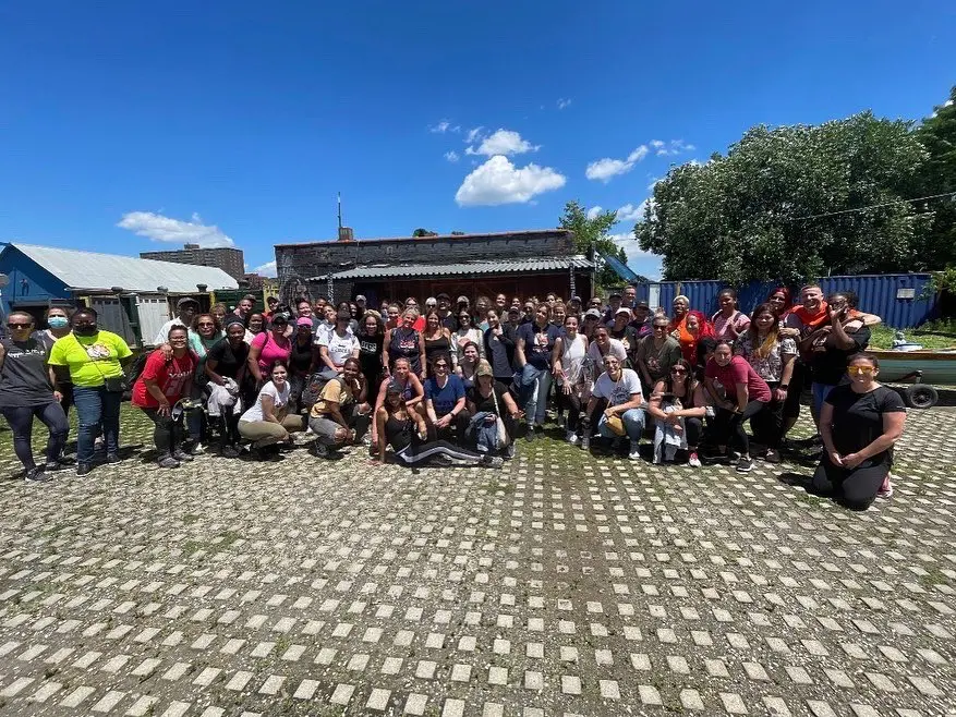 Large group of staff and community members posing outdoors together