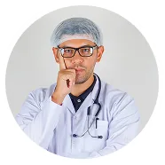 Male doctor wearing a white coat and hairnet, with a stethoscope, thinking with hand on chin.