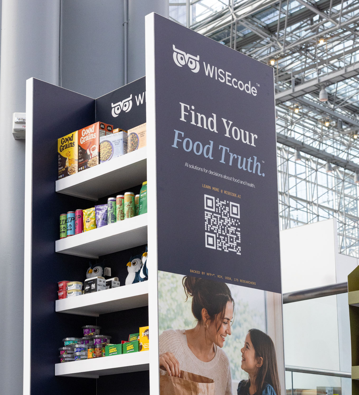 WISEcode display with slogan 'Find Your Food Truth' above shelves filled with food products and a mother and daughter photo.