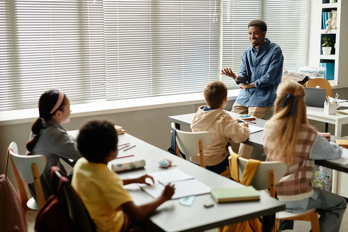 Teacher engaging a small group of elementary students during a lesson at the front of the classroom