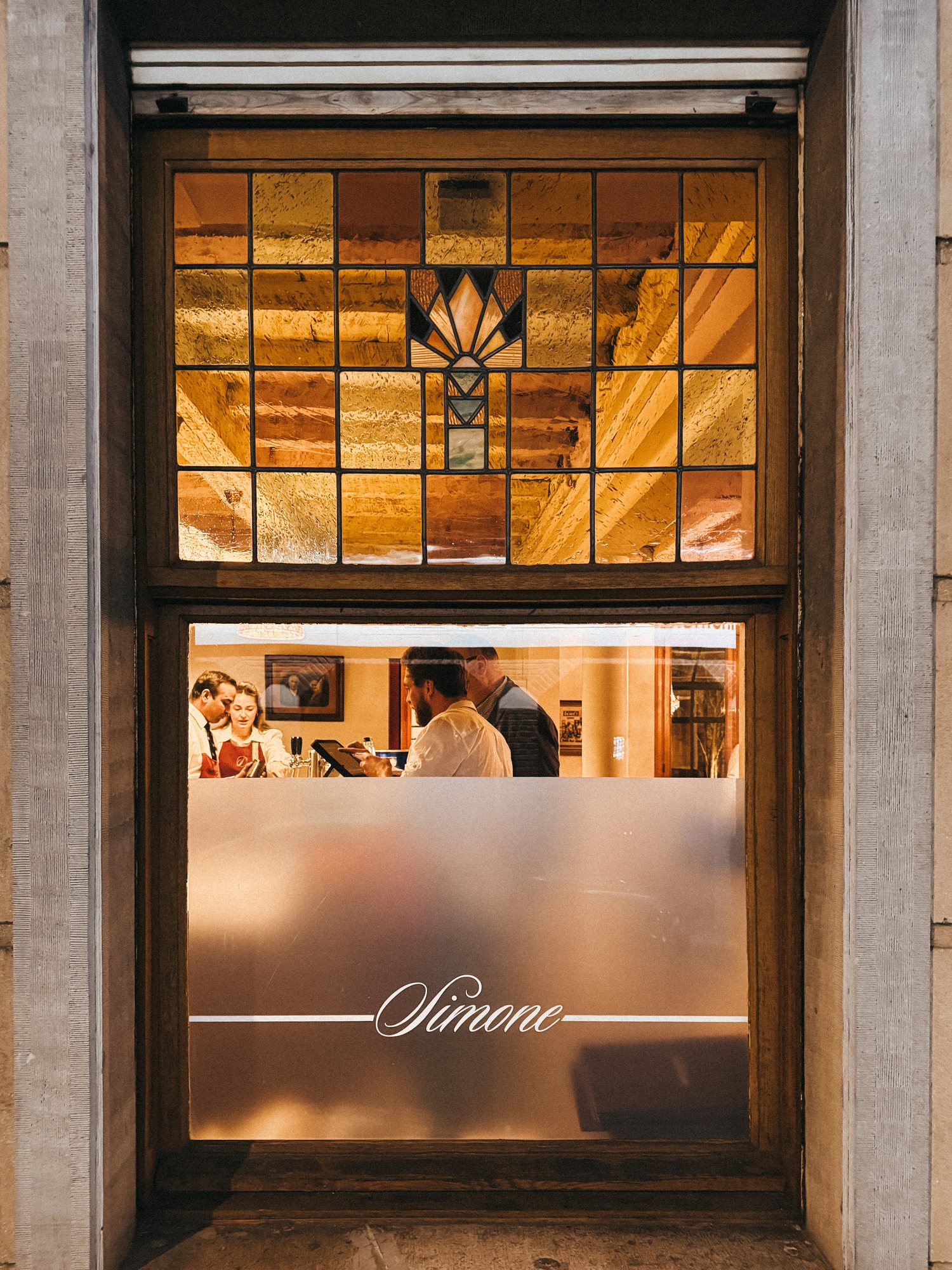 La vitrine de Simone le soir, le nom calligraphié sur le verre dépoli