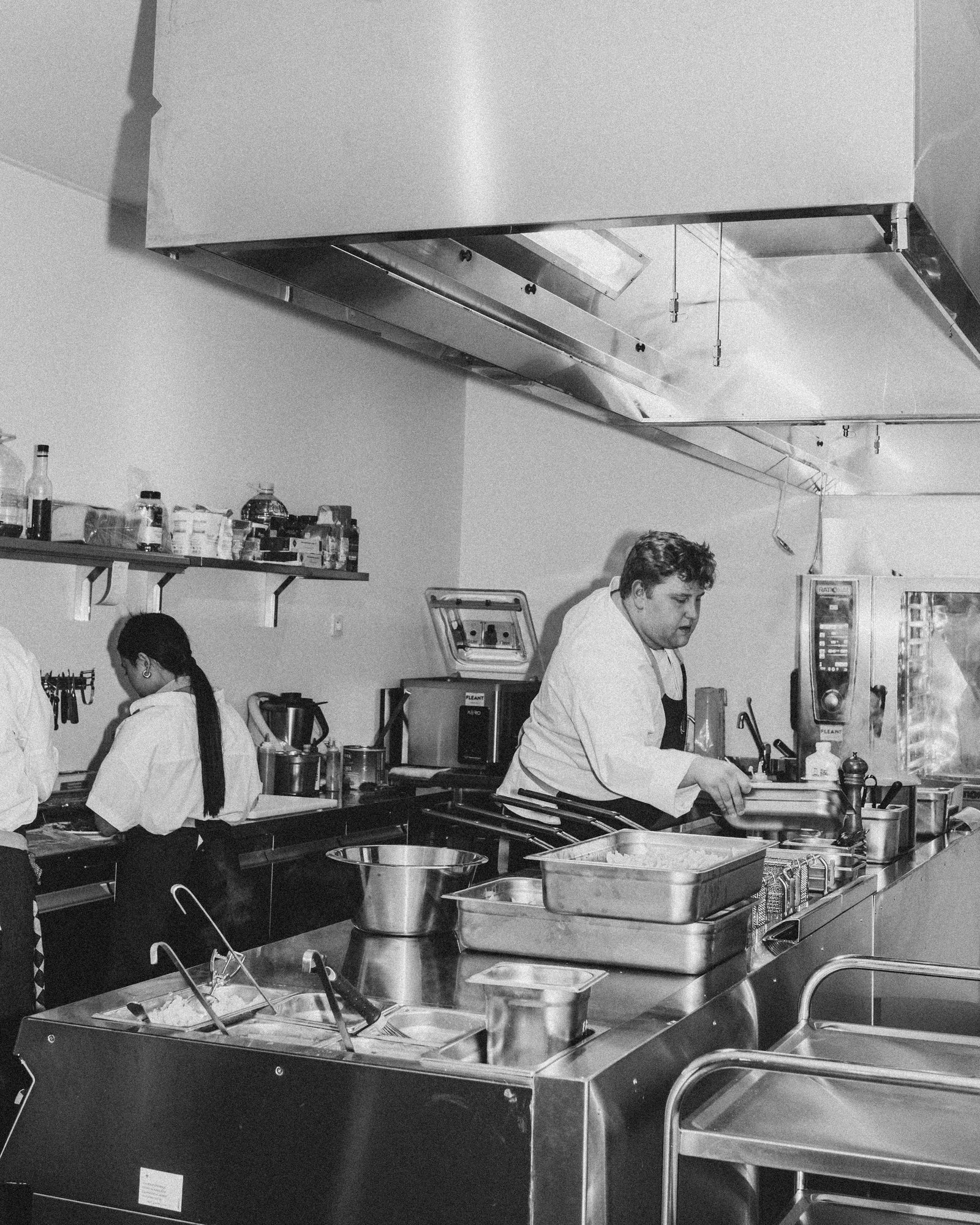 L’équipe en cuisine au travail, photographiée en noir et blanc