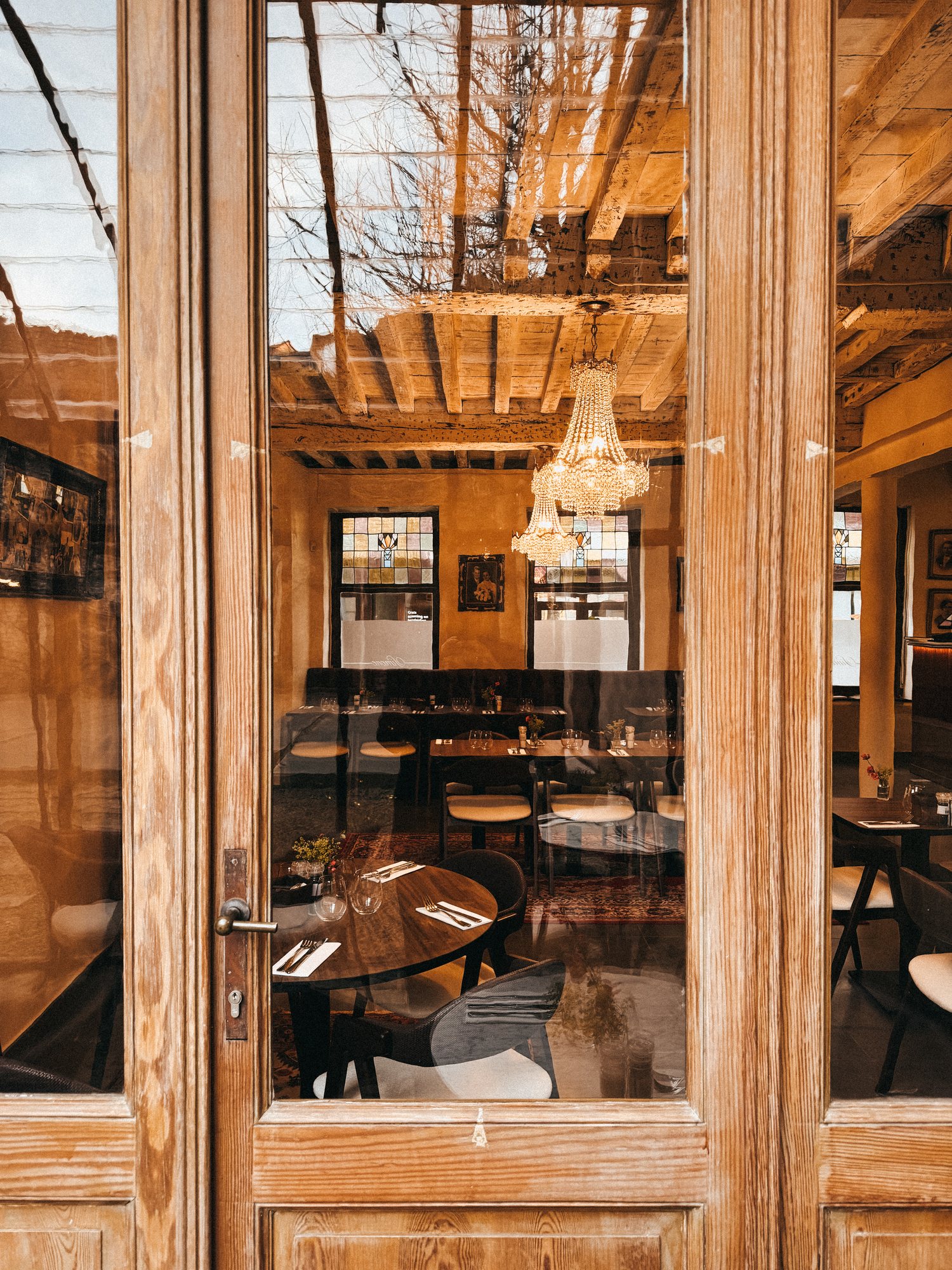 La salle vue depuis la porte d’entrée, les lustres au-dessus des tables dressées