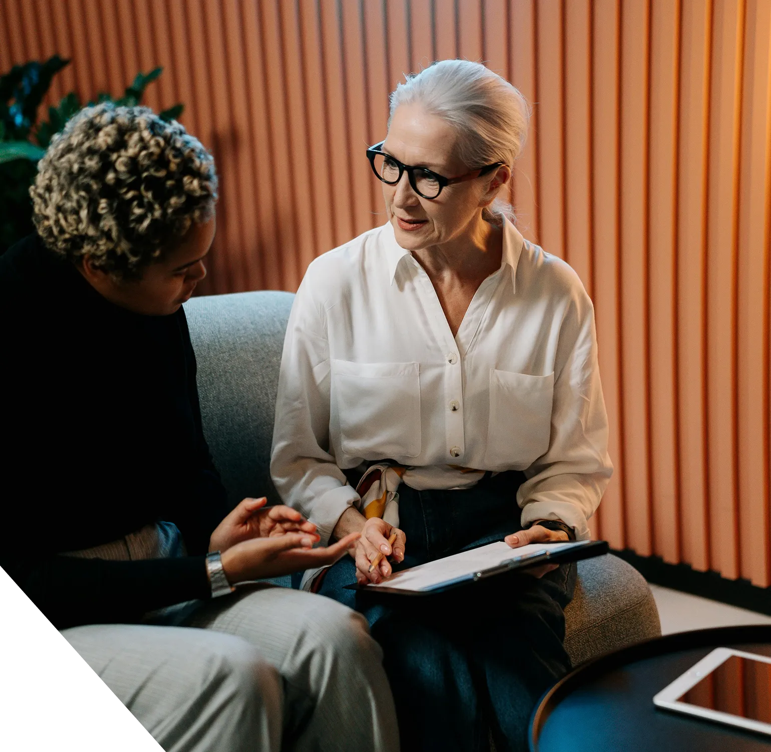 Deux consultantes échangent autour de documents de travail.