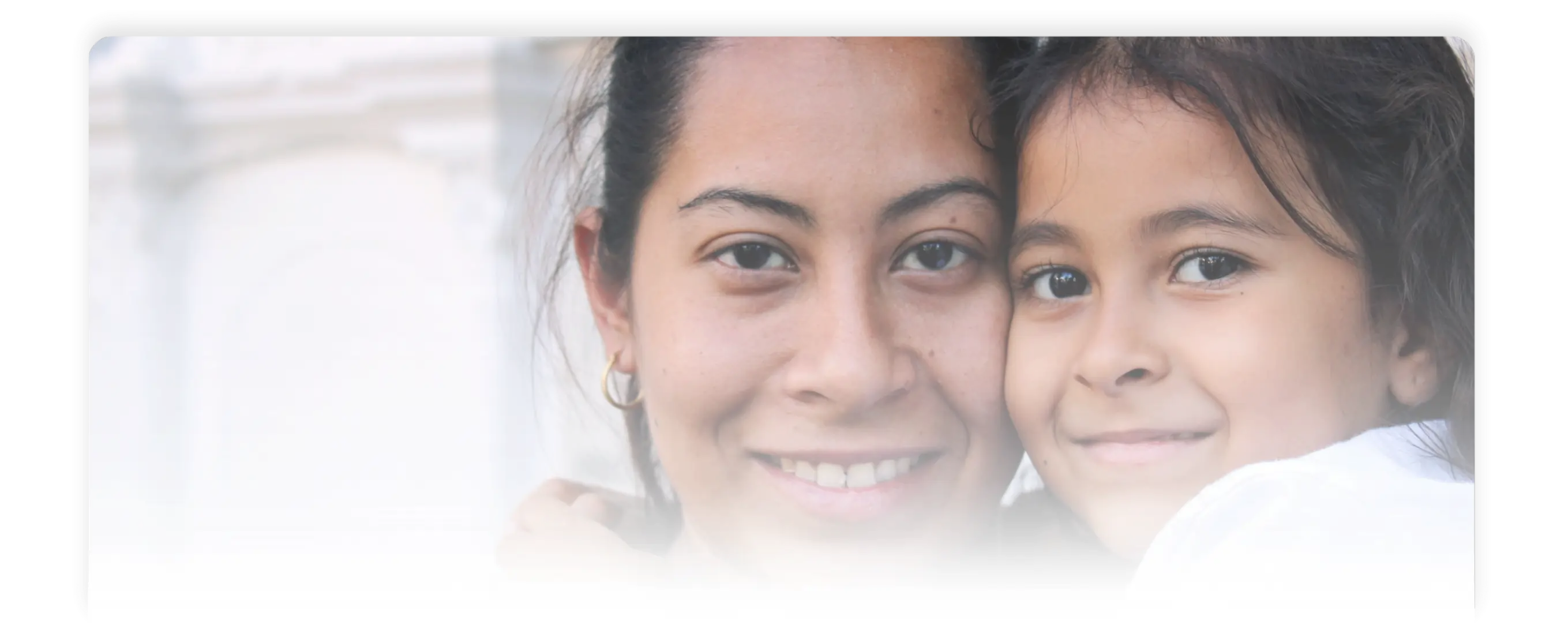 Madre e hija abrazadas y sonrientes, mostrando afecto y cercanía en la foto.