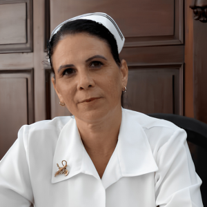 Retrato Maylin. Enfermera con uniforme blanco y cofia en un entorno interior.