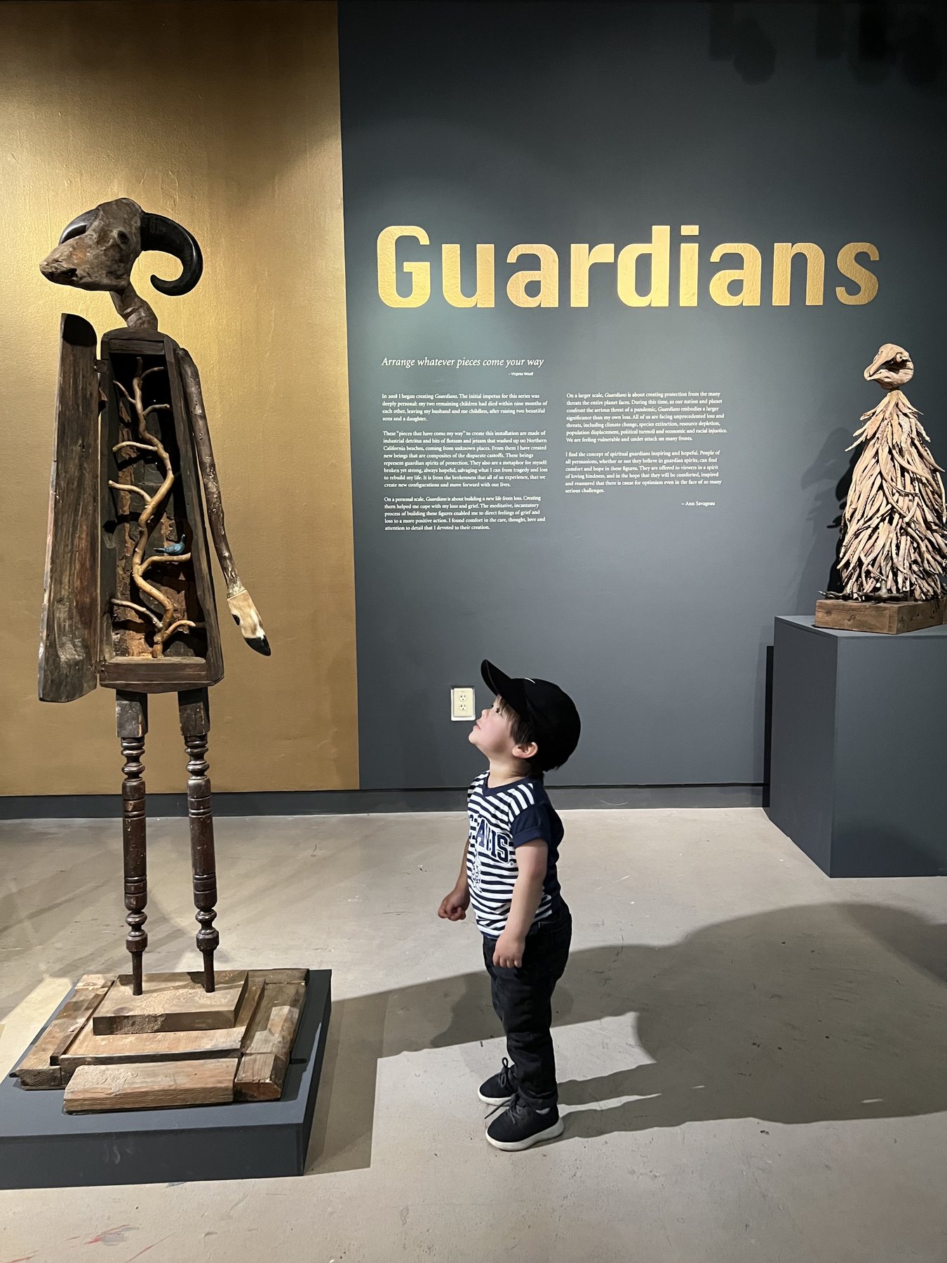 A child standing before the Guardians title wall