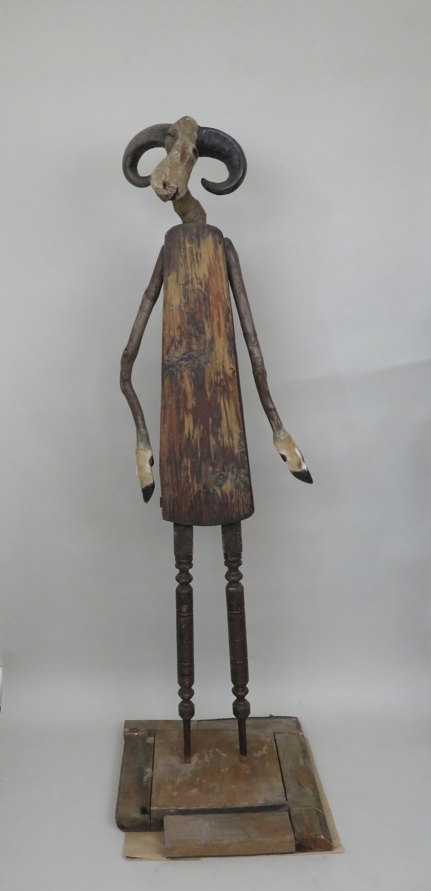 A pale antlered guardian against a white wall