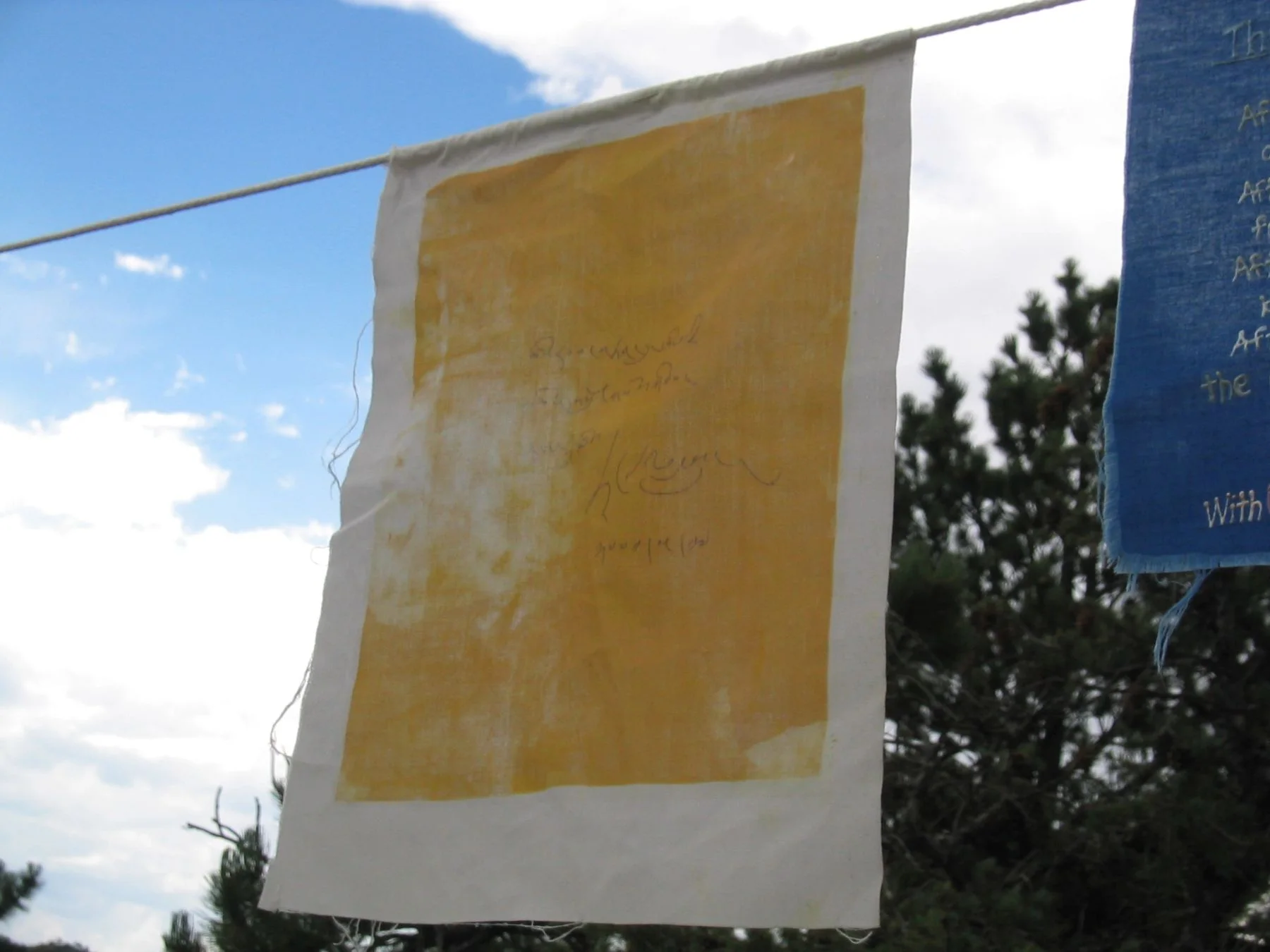 A yellow prayer flag signed by the Dalai Lama