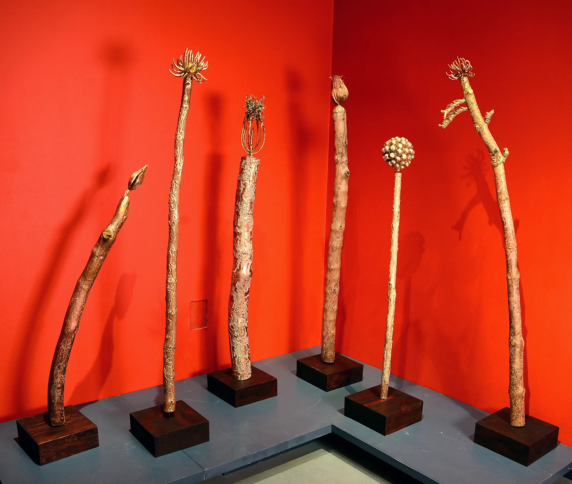Six totems on a red wall