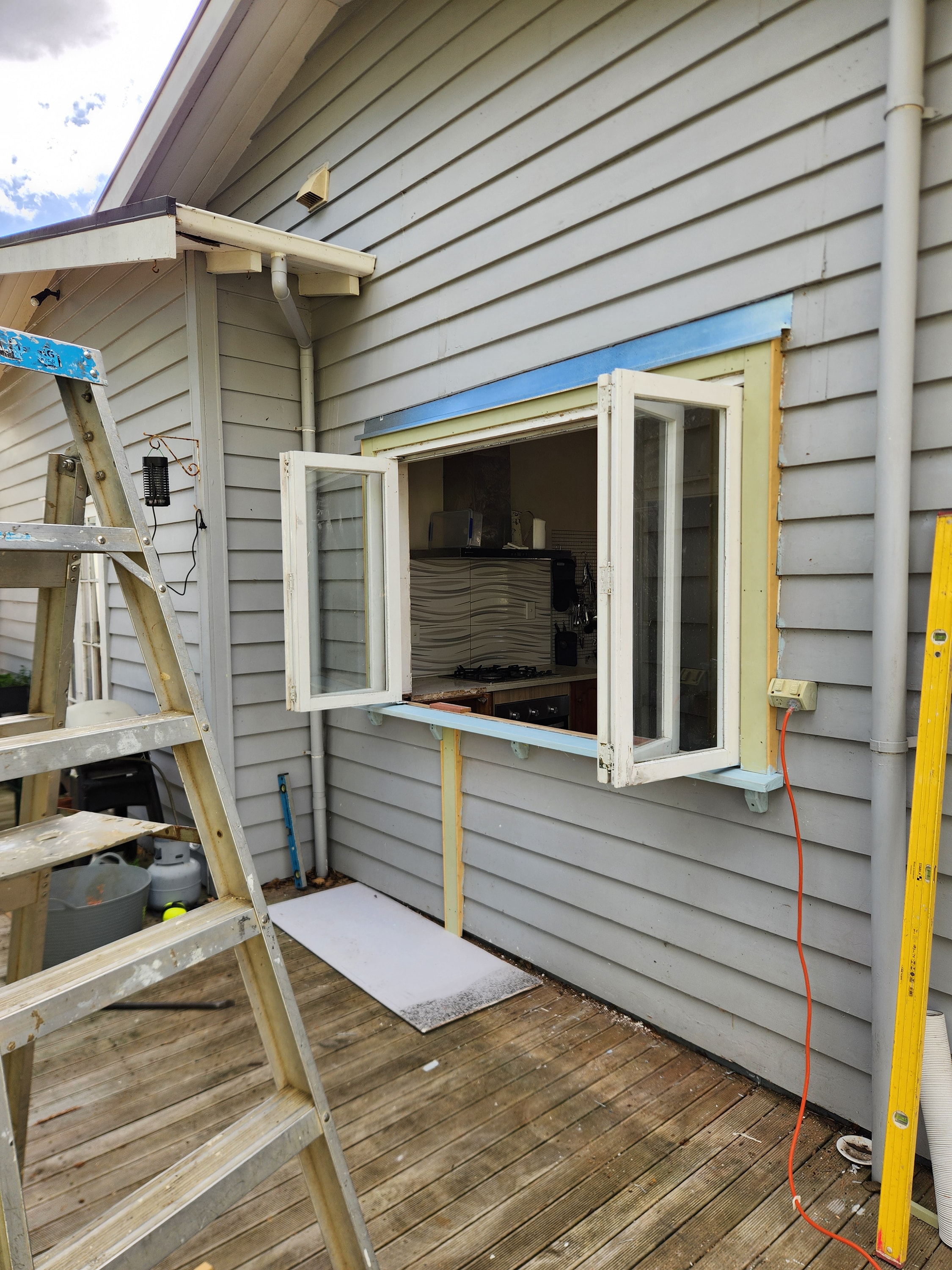 Bi-fold servery window opening from the kitchen onto the deck
