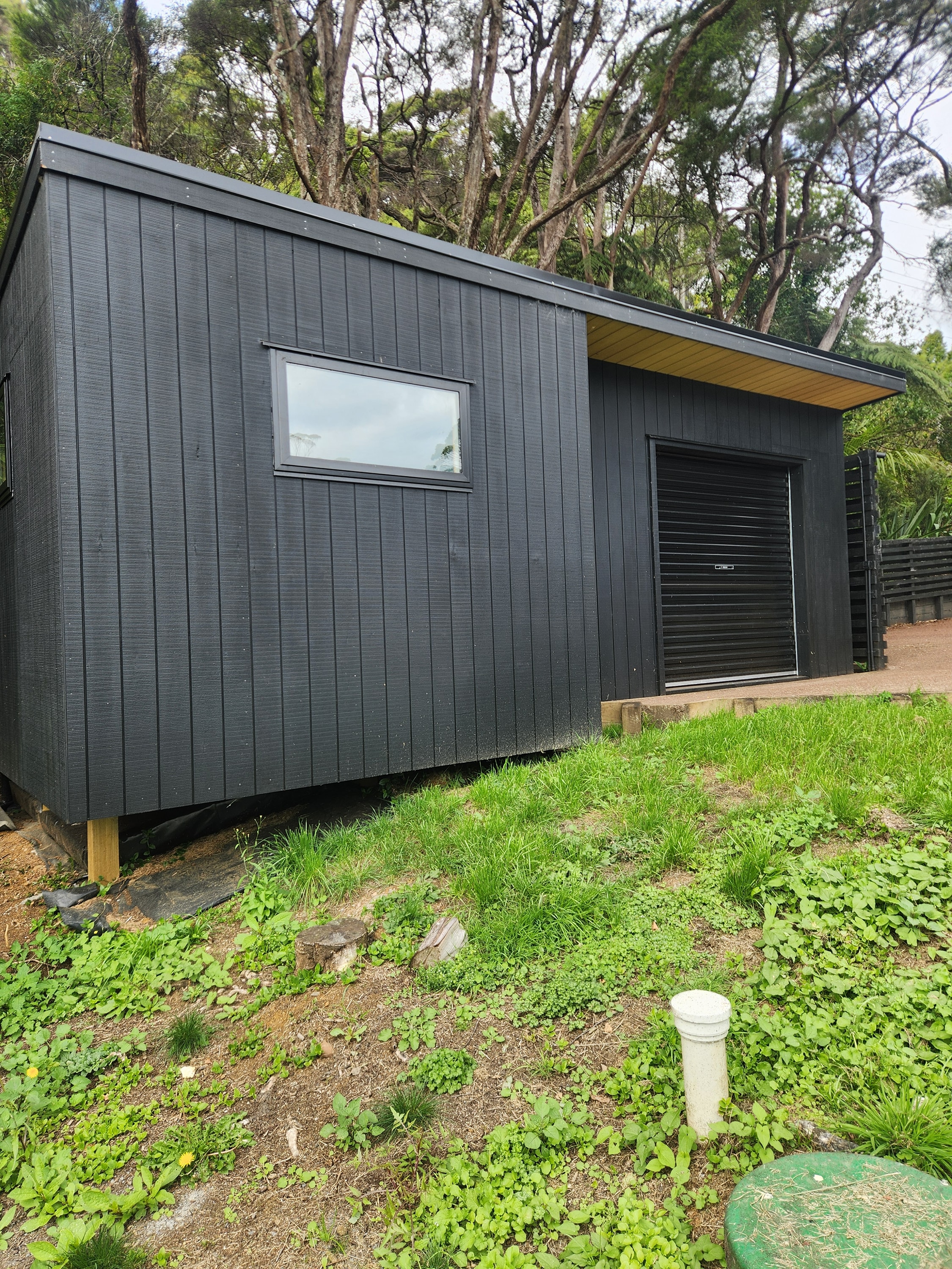 Black cedar-clad garage and sleepout built in Auckland