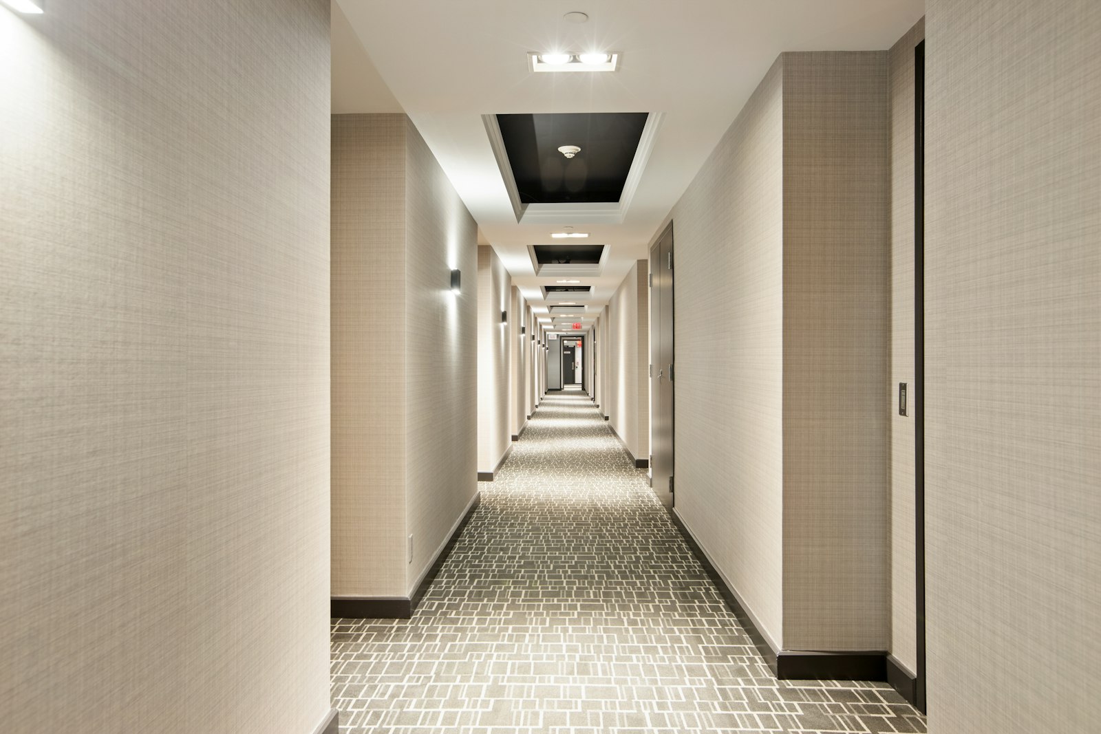 Lit hotel corridor lined with guest room doors
