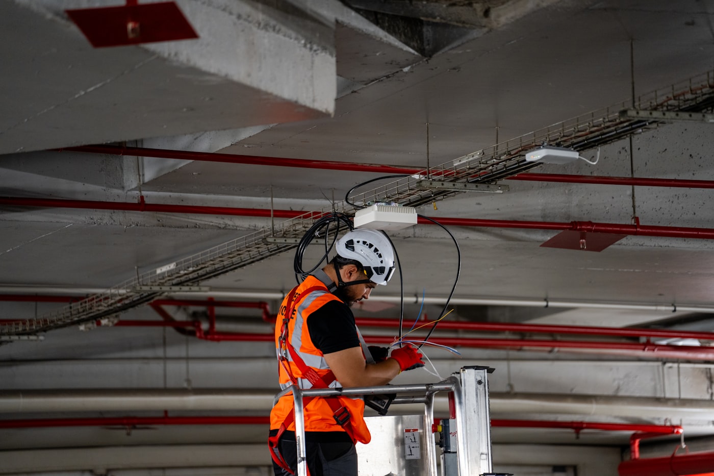 Contractor on a lift installing services in a ceiling