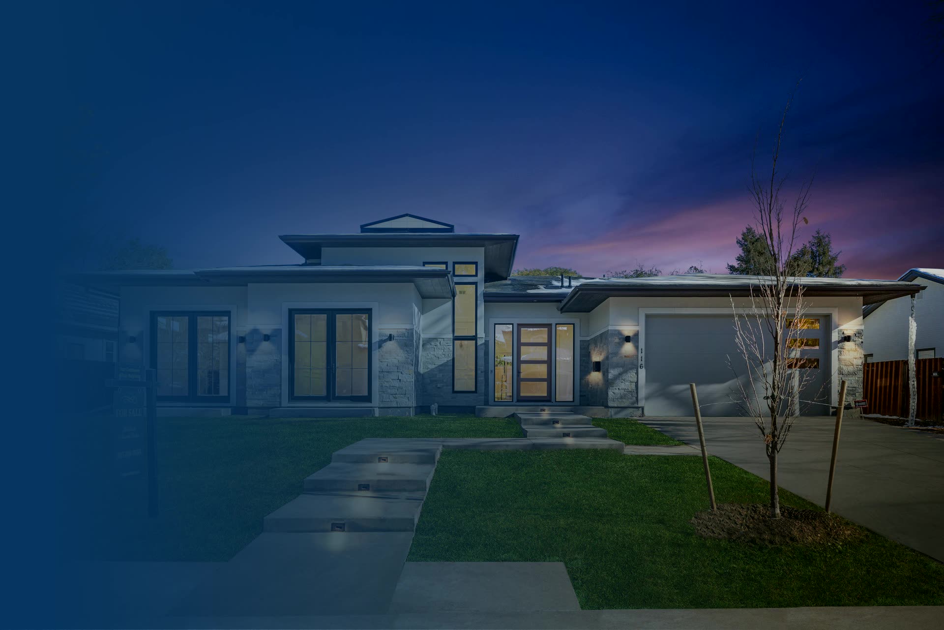 Newly built home at dusk with exterior and interior lighting on
