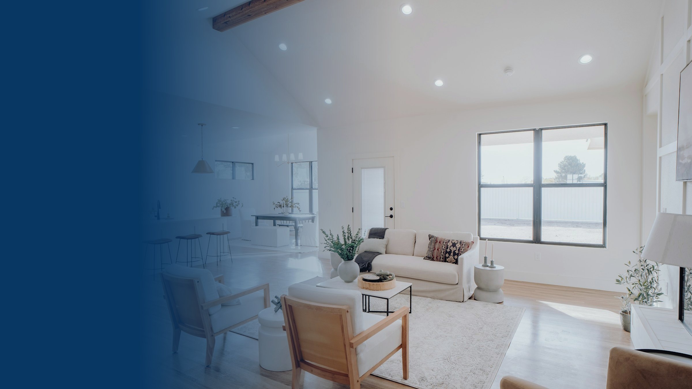 Open-plan living, dining and kitchen space with recessed downlights, pendants and large windows