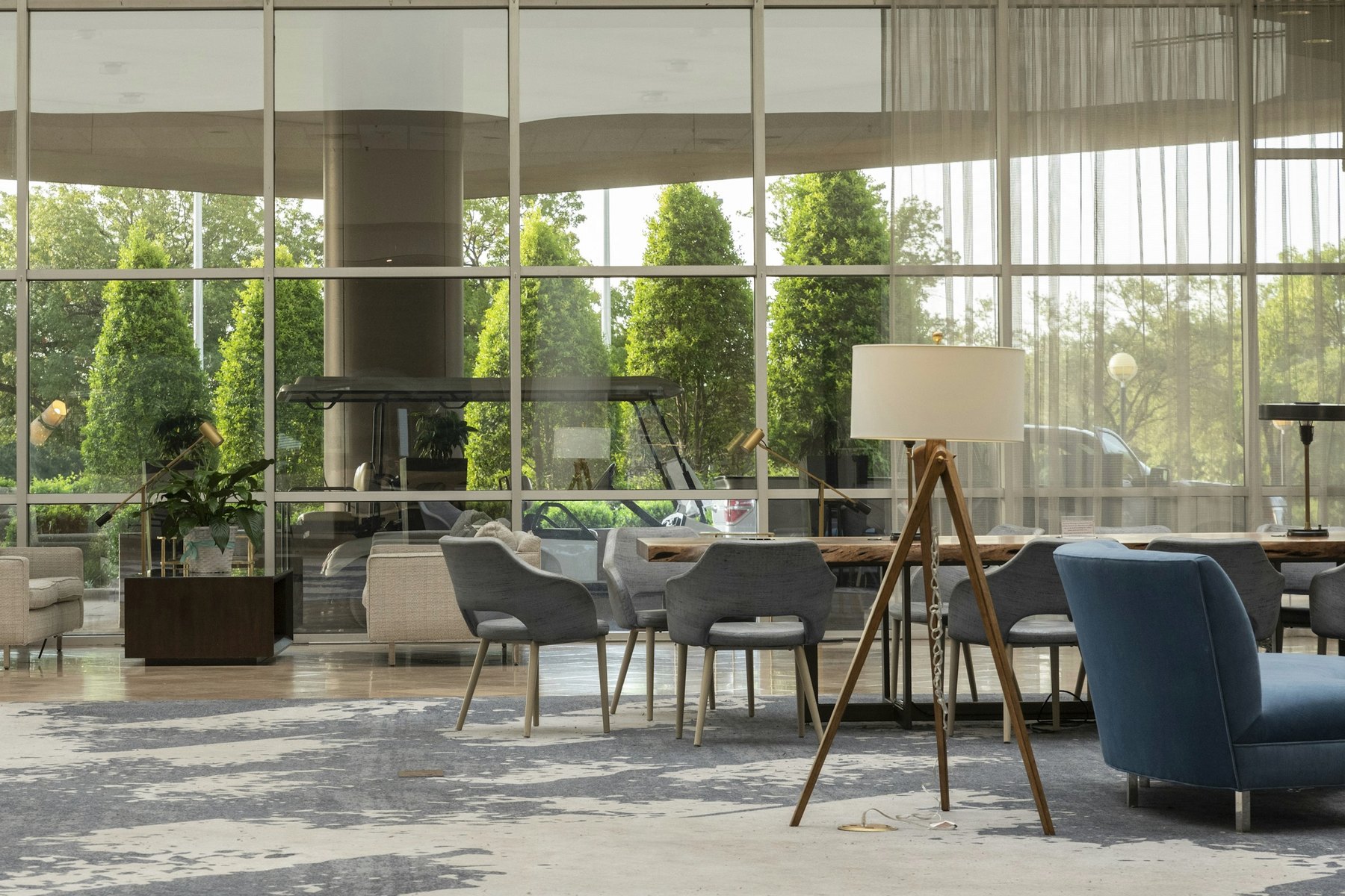 Clubhouse amenity lounge with full-height glazing, communal table and lounge seating