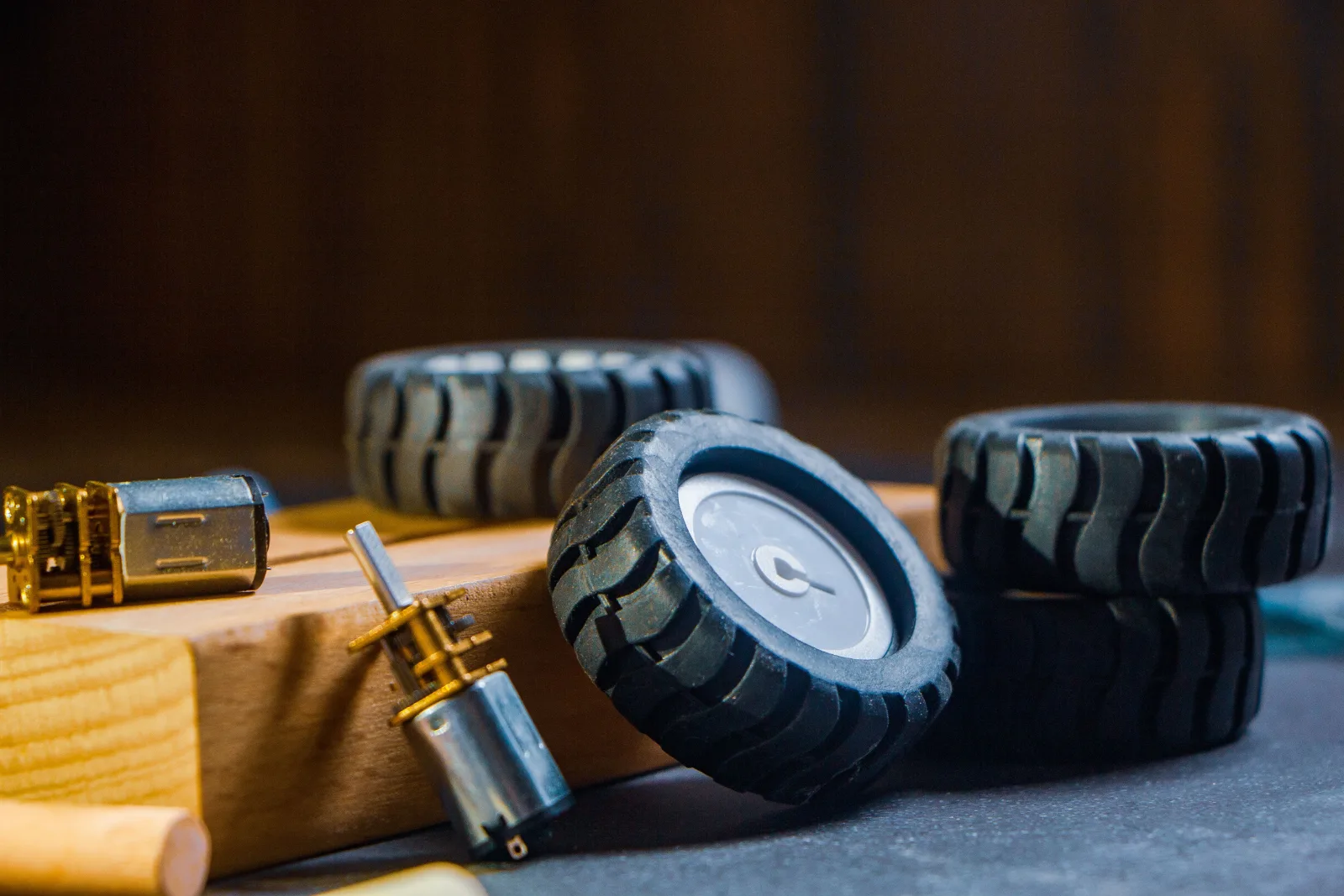 Spare robot wheels and drive motors laid out on a workbench