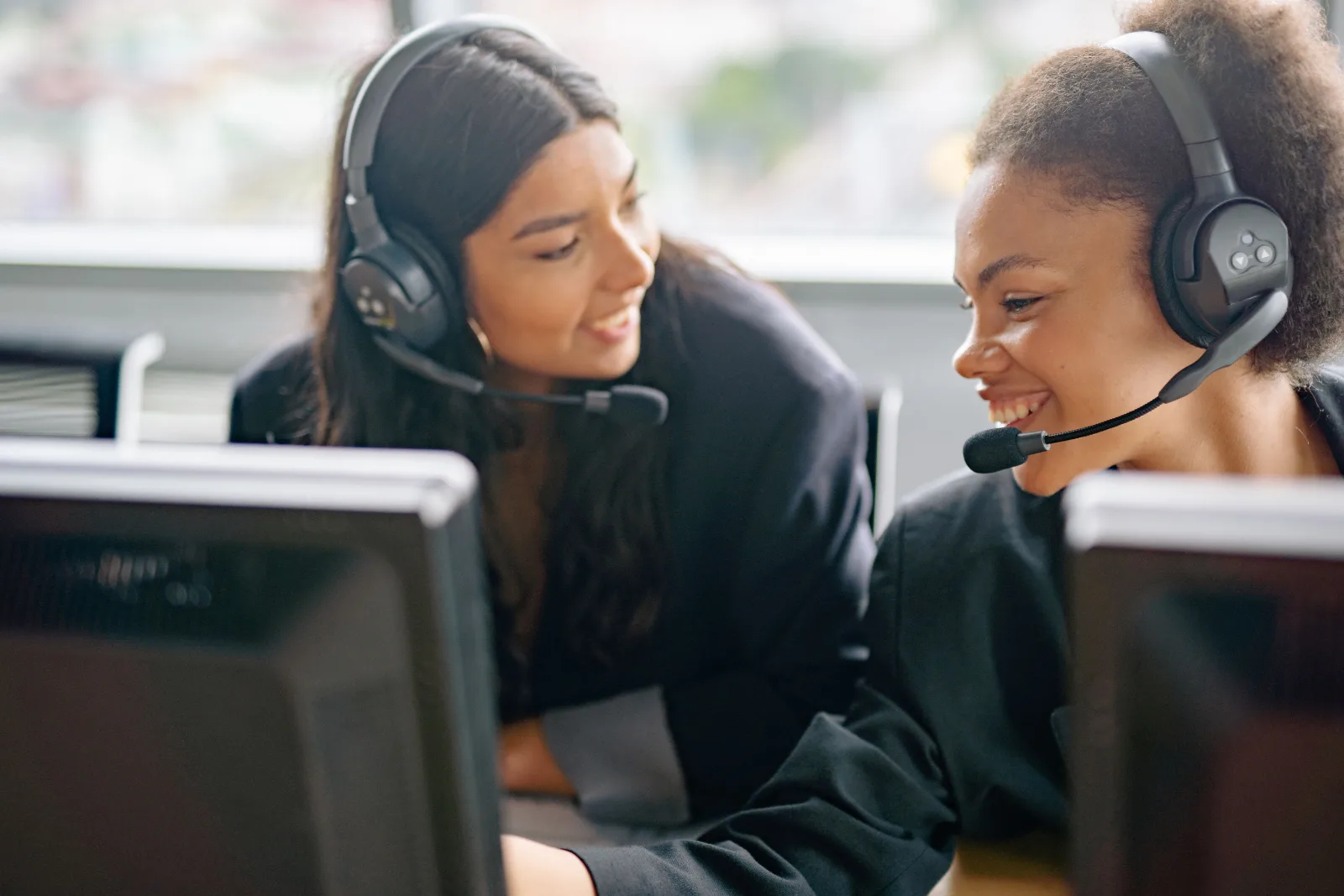Two operations centre agents with headsets working at monitors