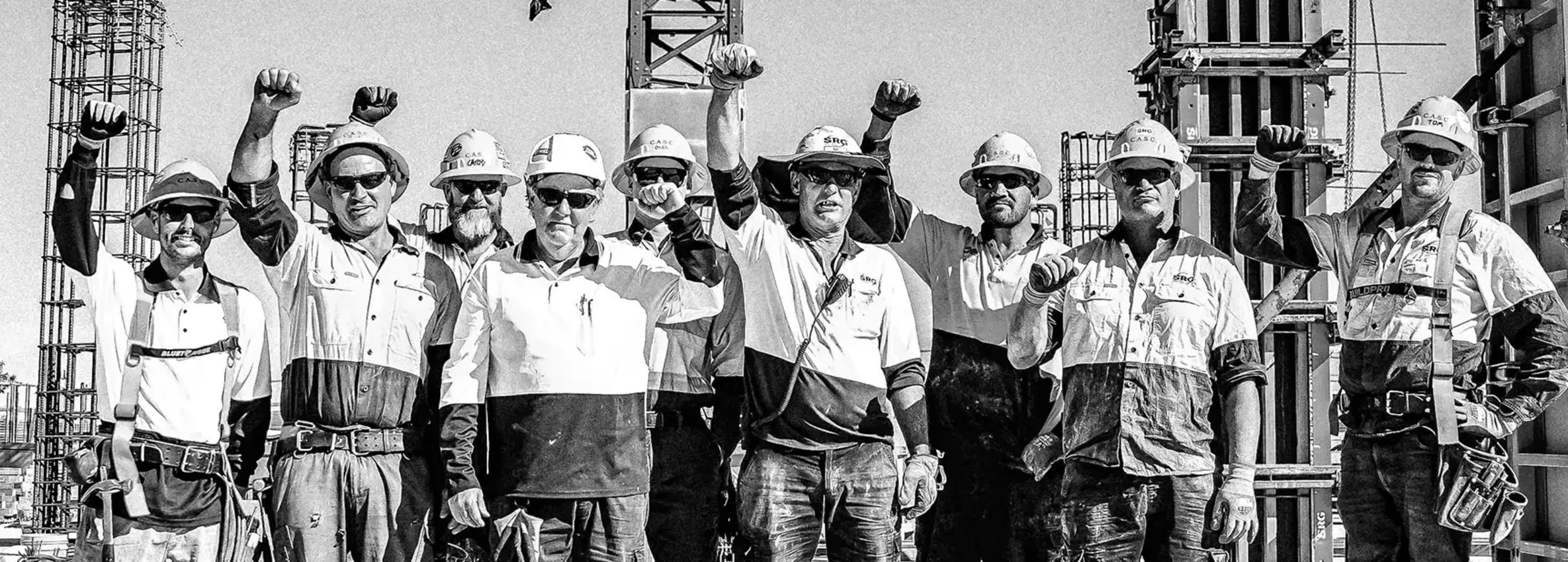 Construction workers raising their fists in solidarity on site