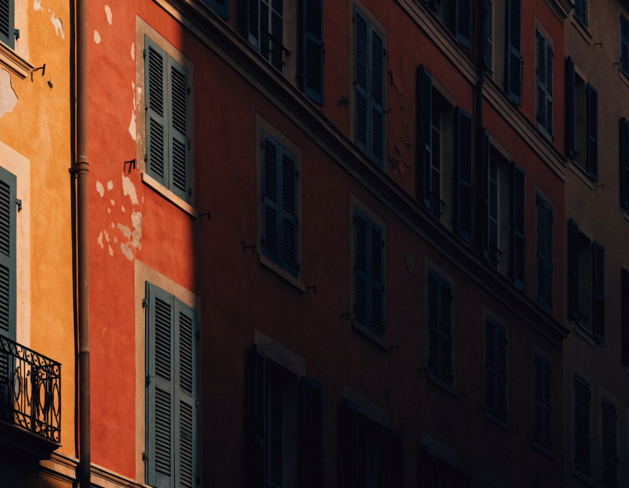 Façades ocre et volets clos du Vieux-Nice, secteur sauvegardé relevant du droit de l'urbanisme
