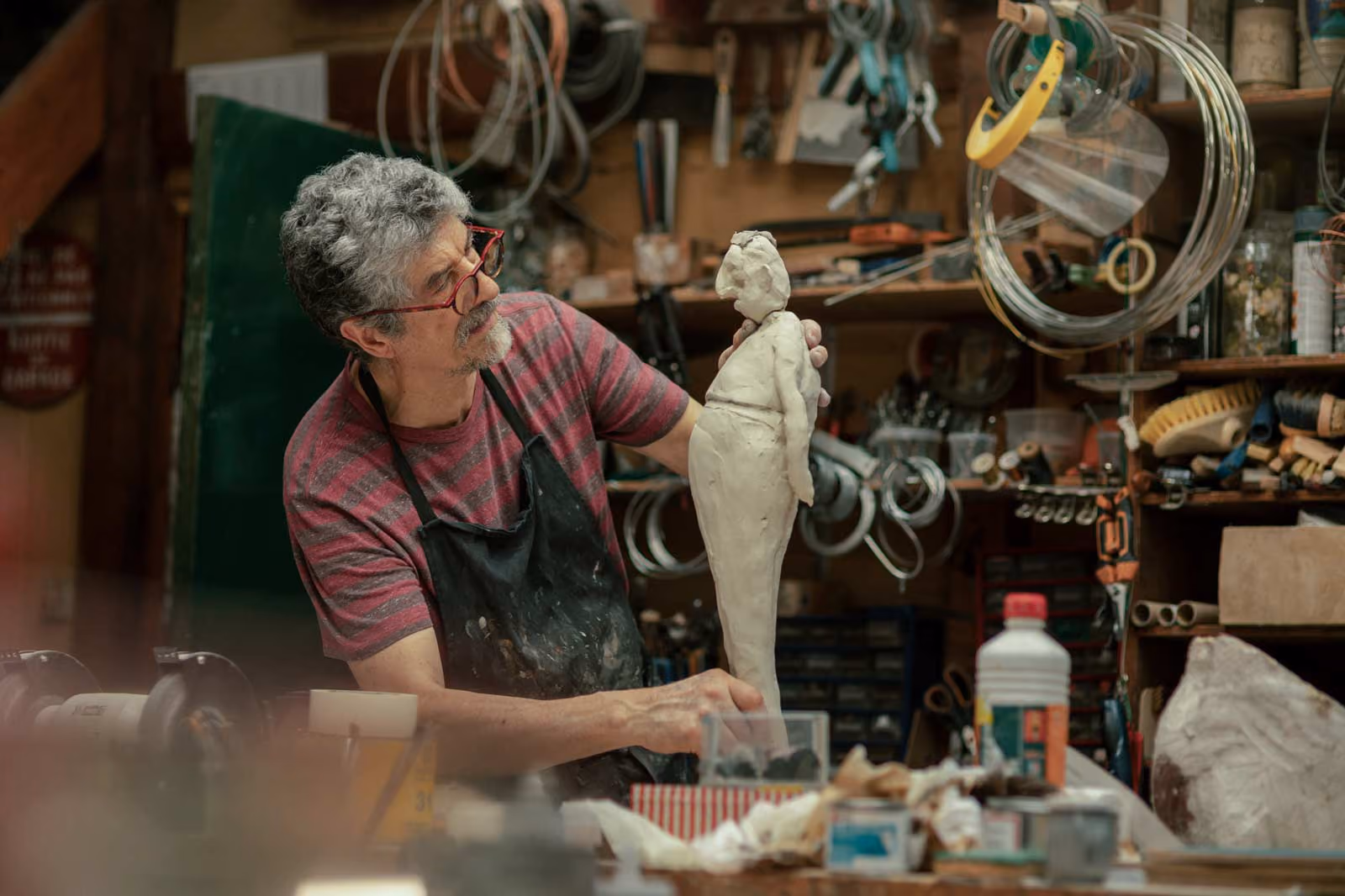 Guillermo Forchino in his workshop, holding one of his white sculpted figures