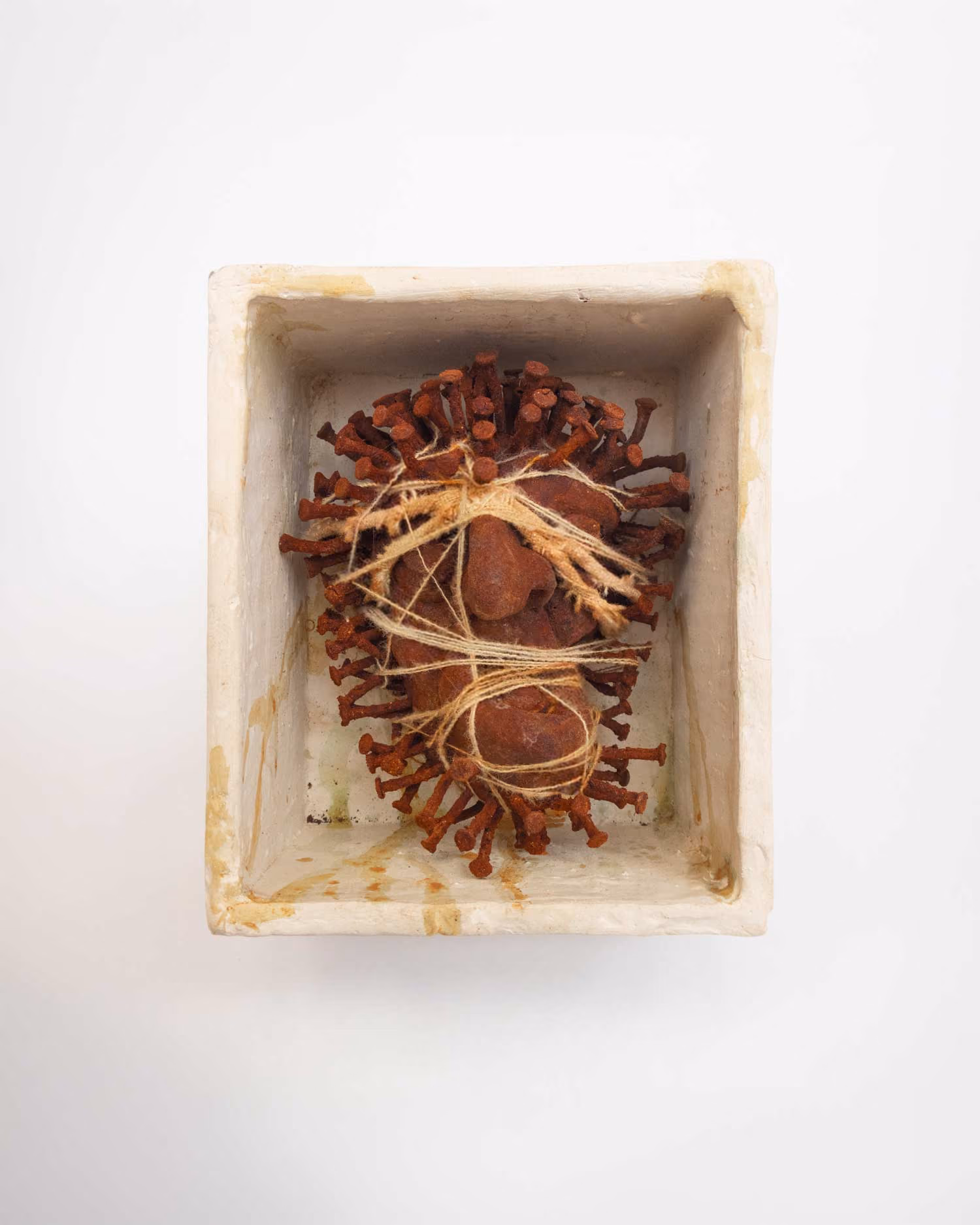 Guillermo Forchino sculpture of a rust-coloured figure bound with twine inside a white box