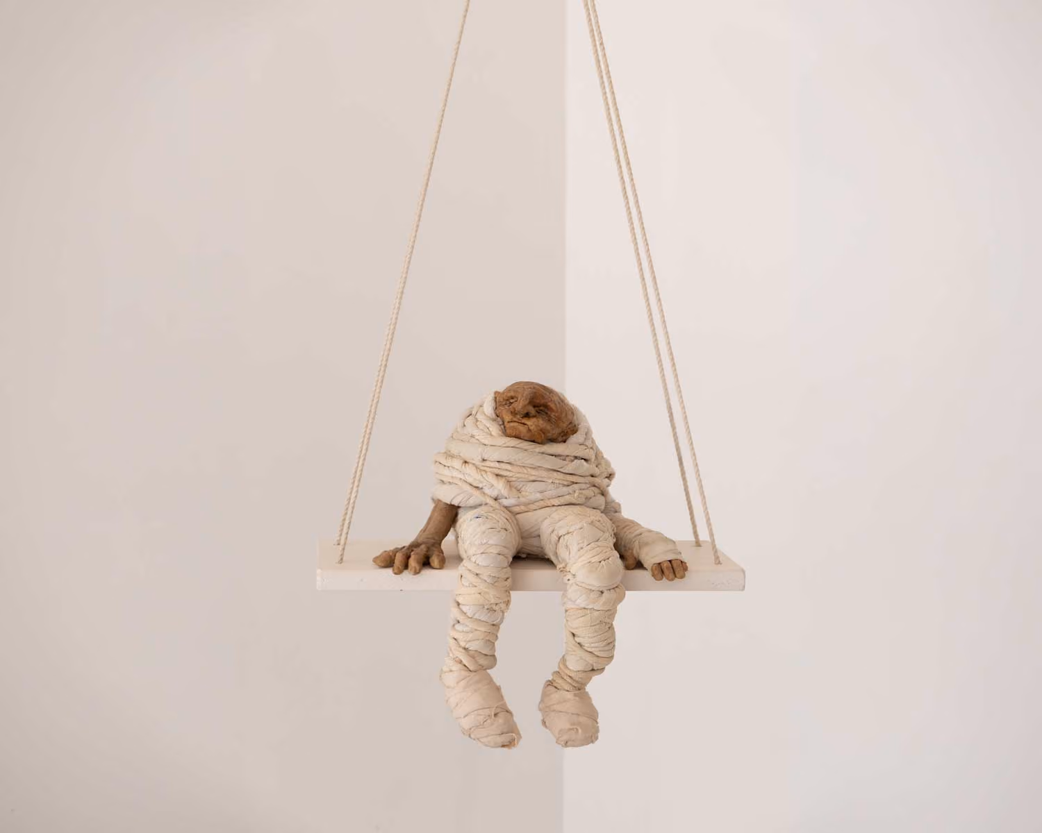 Guillermo Forchino sculpture of a figure sitting on a rope swing