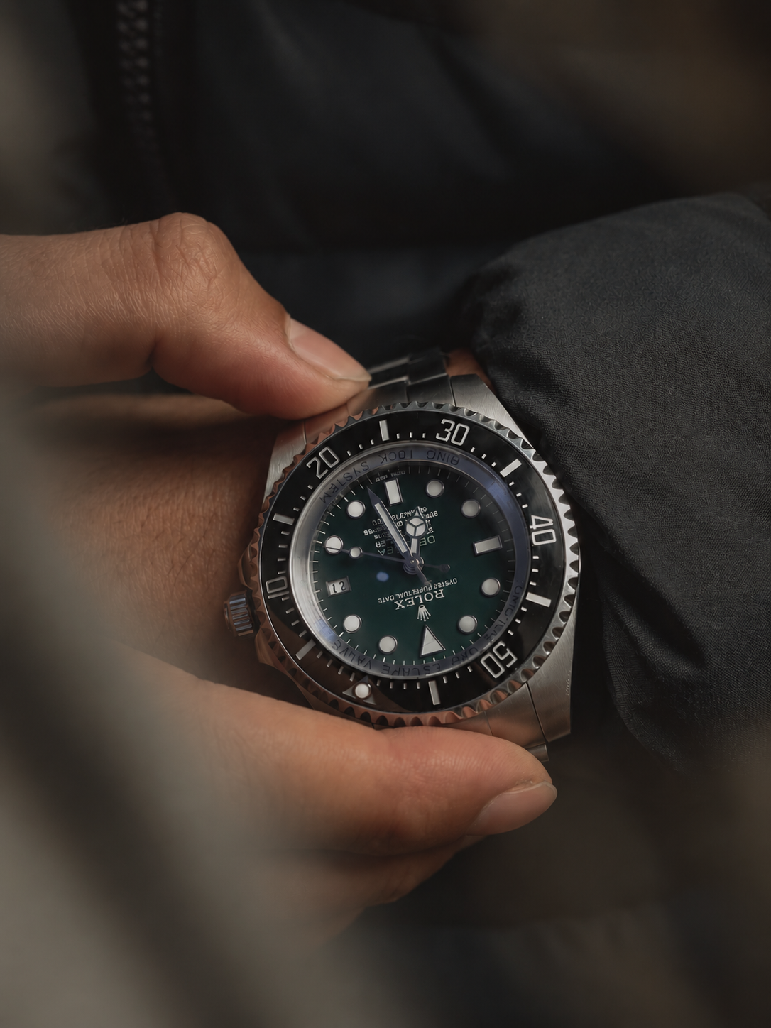 Close-up of a hand holding a luxury dive watch
