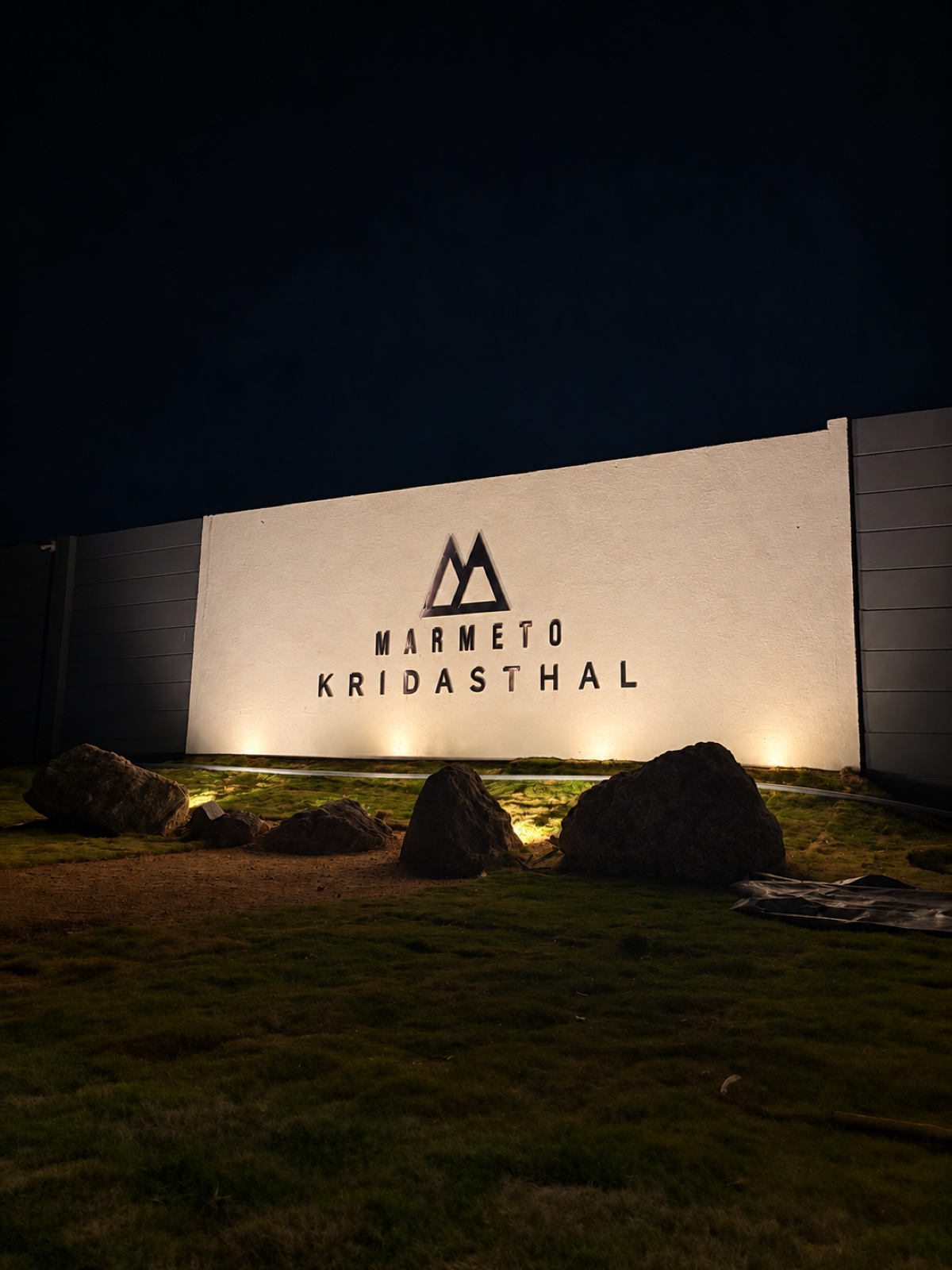 The illuminated Marmeto Kridasthal entrance sign at night