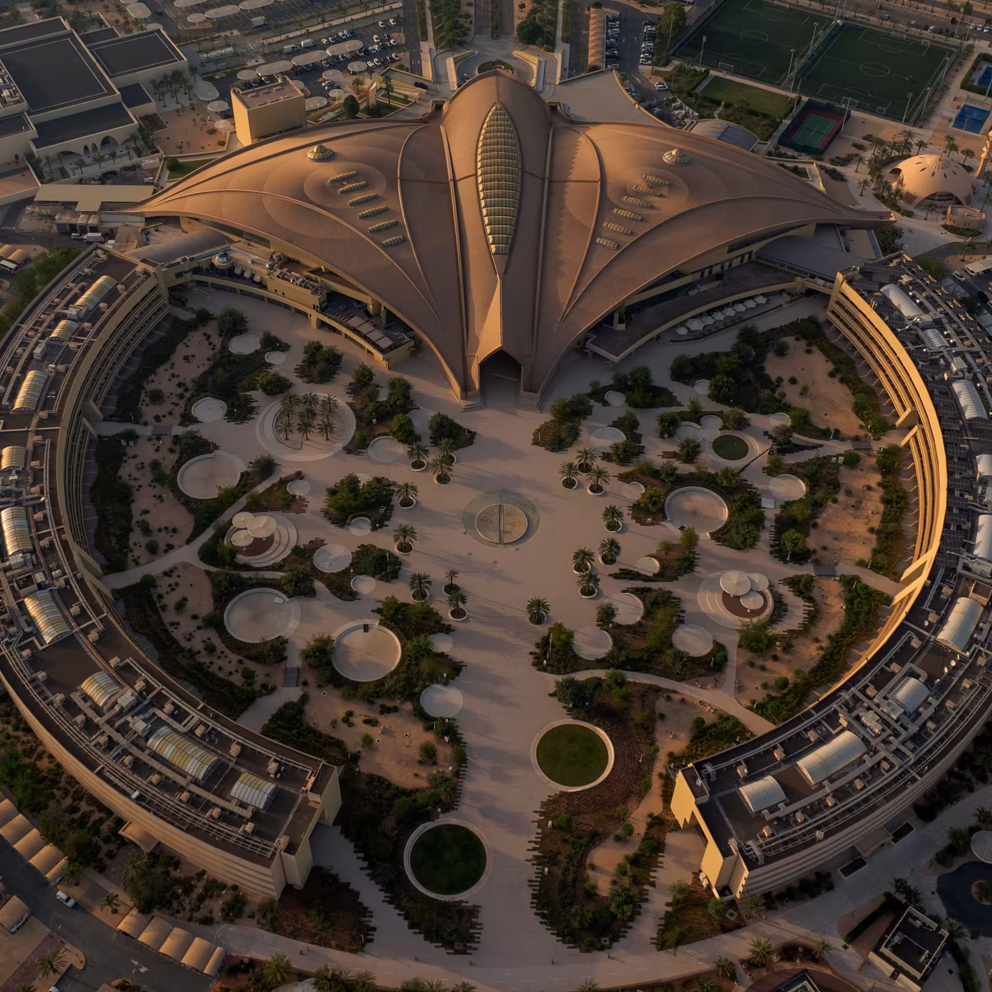 Aerial view of a circular building complex with landscaped gardens