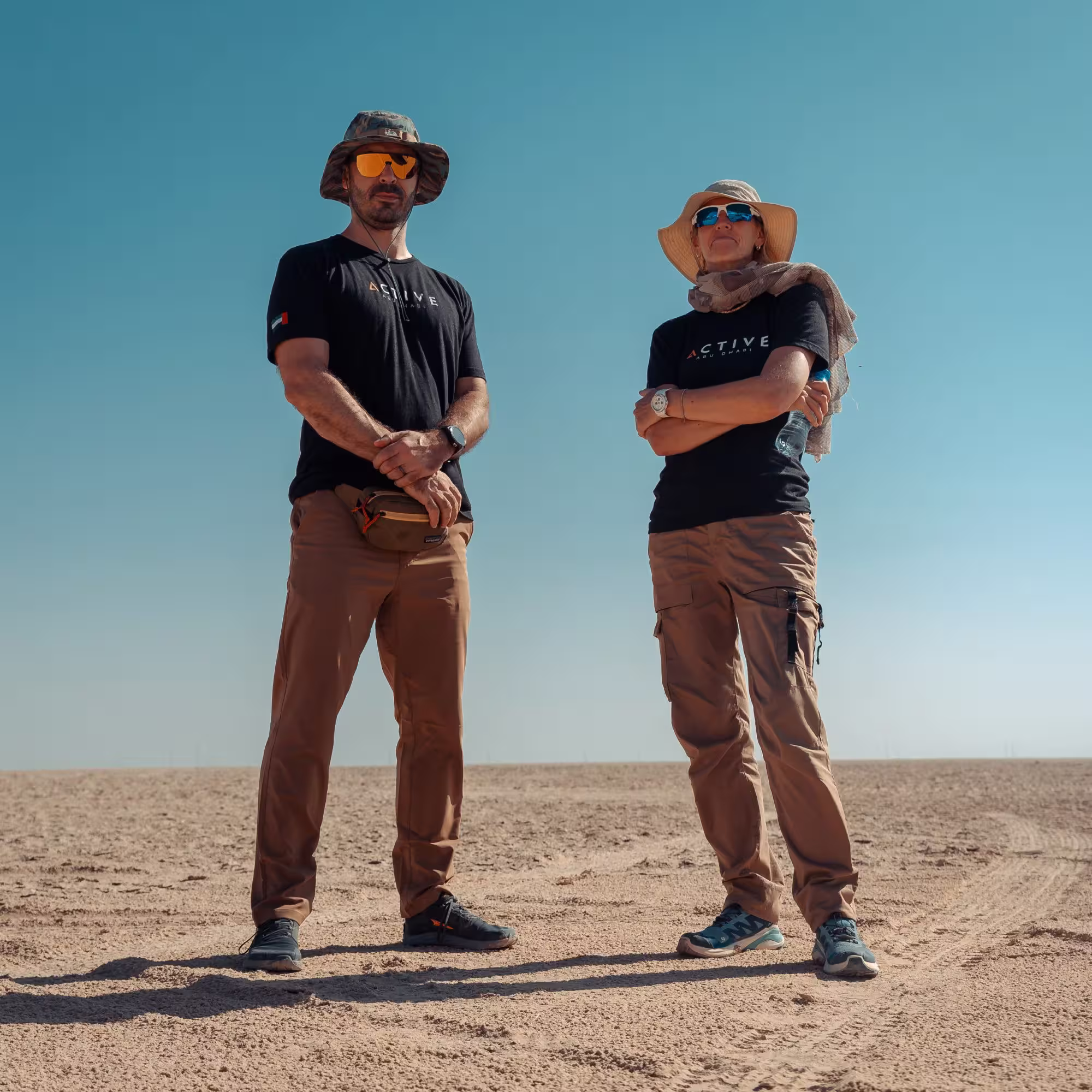 Two men in matching branded t-shirts standing in the desert
