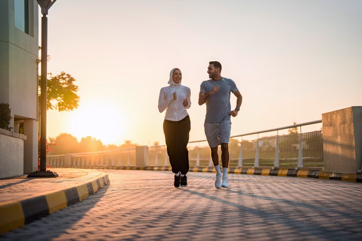 Coach and athlete jogging together outdoors in conversation