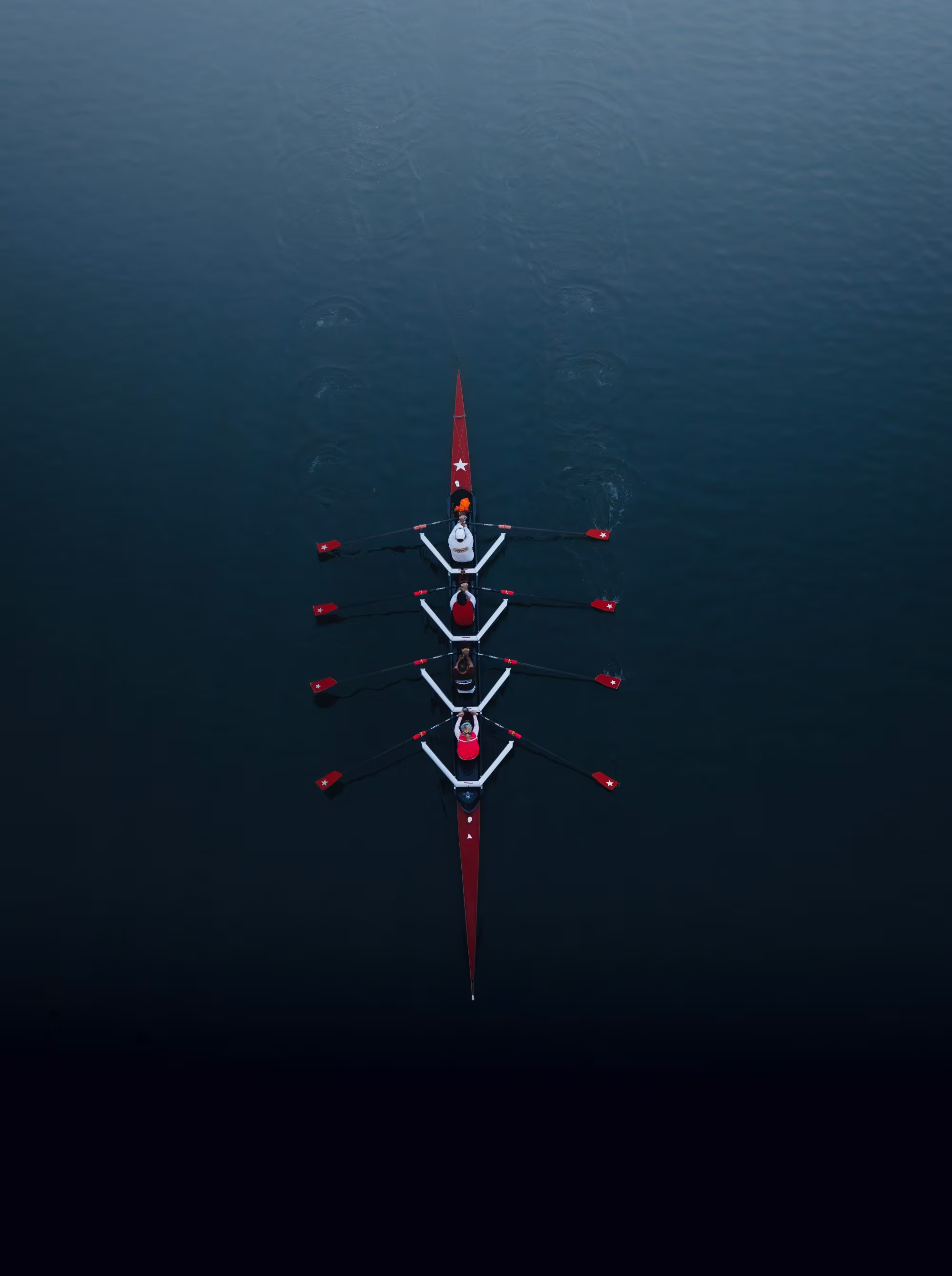 Aerial view of a four-person rowing crew on calm water