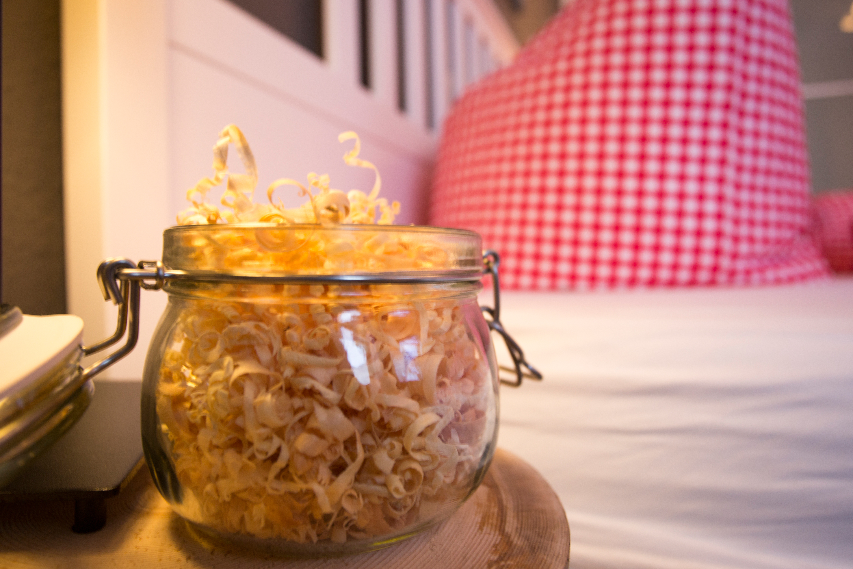 Schlafzimmer der Ferienwohnung Ifenblick mit Holzdeko und rot-weiß kariertem Kissen