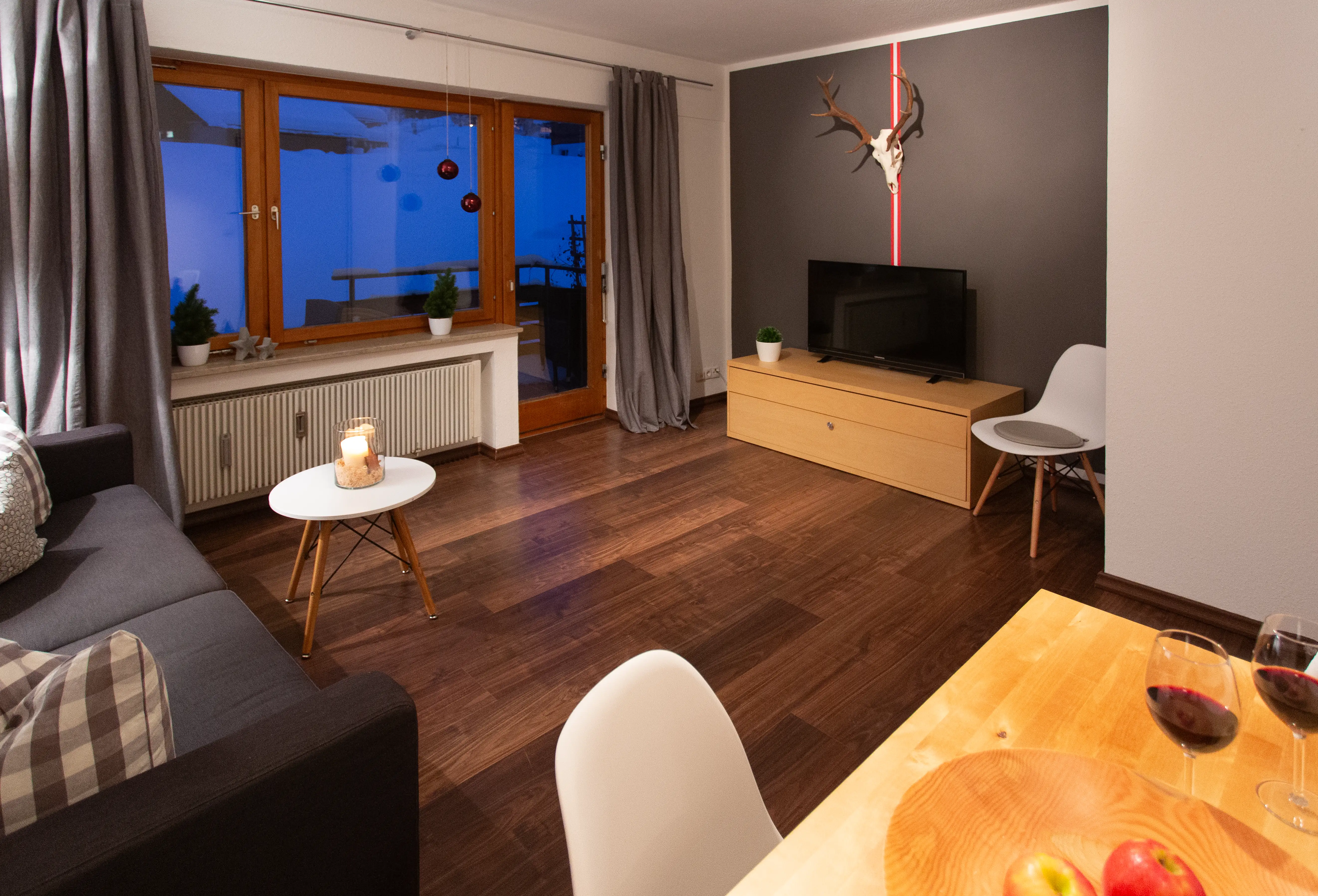 Wohnzimmer der Ferienwohnung Ifenblick mit Sofa, Esstisch und Zugang zur Terrasse