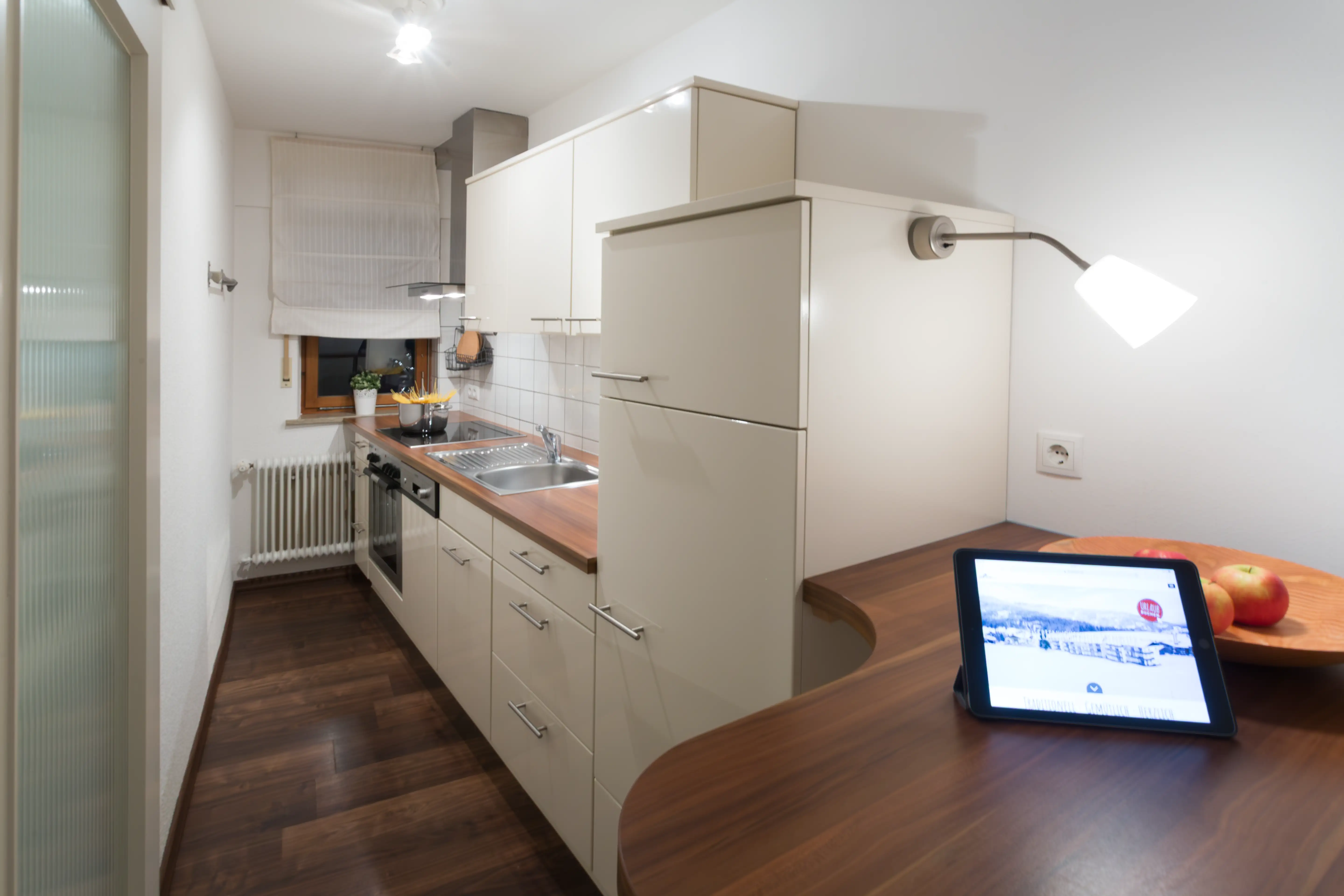 Helle Küchenzeile der Ferienwohnung Ifenblick mit Kühlschrank, Herd und Holztheke