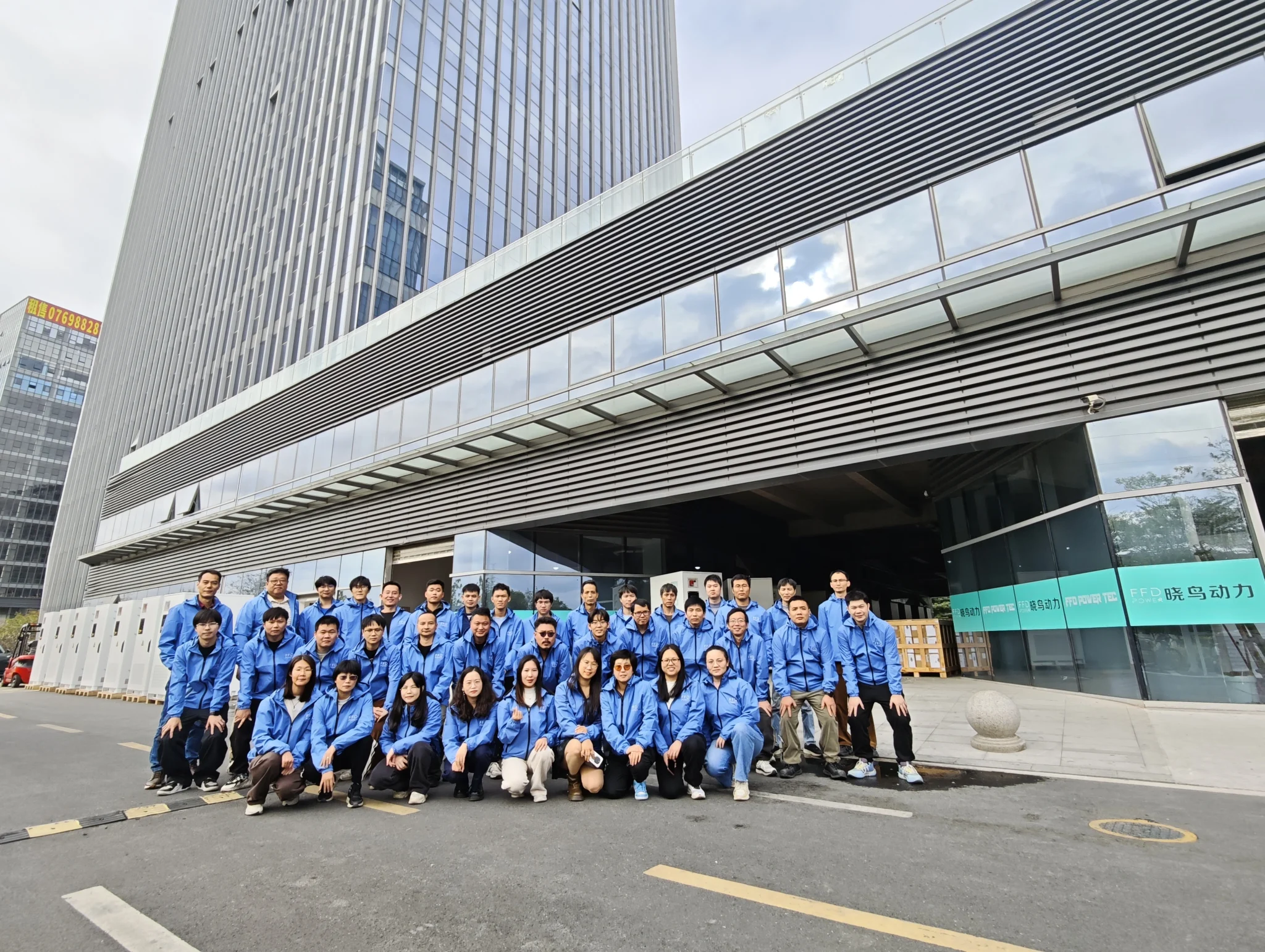 Gruppenfoto des FFD-POWER-Teams in blauen Firmenjacken vor dem Firmengebäude